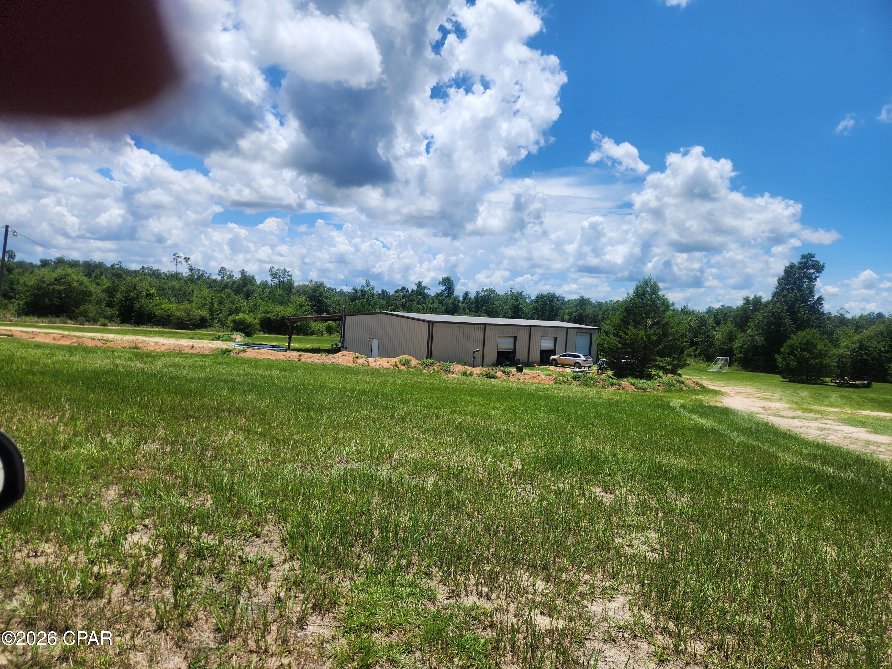Want to get away from everything? This property is perfect to construct the barndominium of your dreams, or just a huge workshop and a weekend getaway.  This 7000 sq.ft steel frame metal building is situated on 4.330 acres. It has 7000 sq.ft. under roof.  The building also has an internal separate living area with 2 bedrooms and 1 bathroom with a separate HVAC to keep cool. The building has 3 roll up garage doors and even a 10-ton hydraulic lift for vehicle or equipment maintenance.  The side also has a steel frame covered area attached to park everything you need to keep it out of the weather.  If you have been looking for a large steel frame well-built building, you need to look at this one. You have room for expansion to make the building anything you want all on concrete.  The outside acreage would allow additional space to build a house or mobile home. So much potential, and not too far from town.
