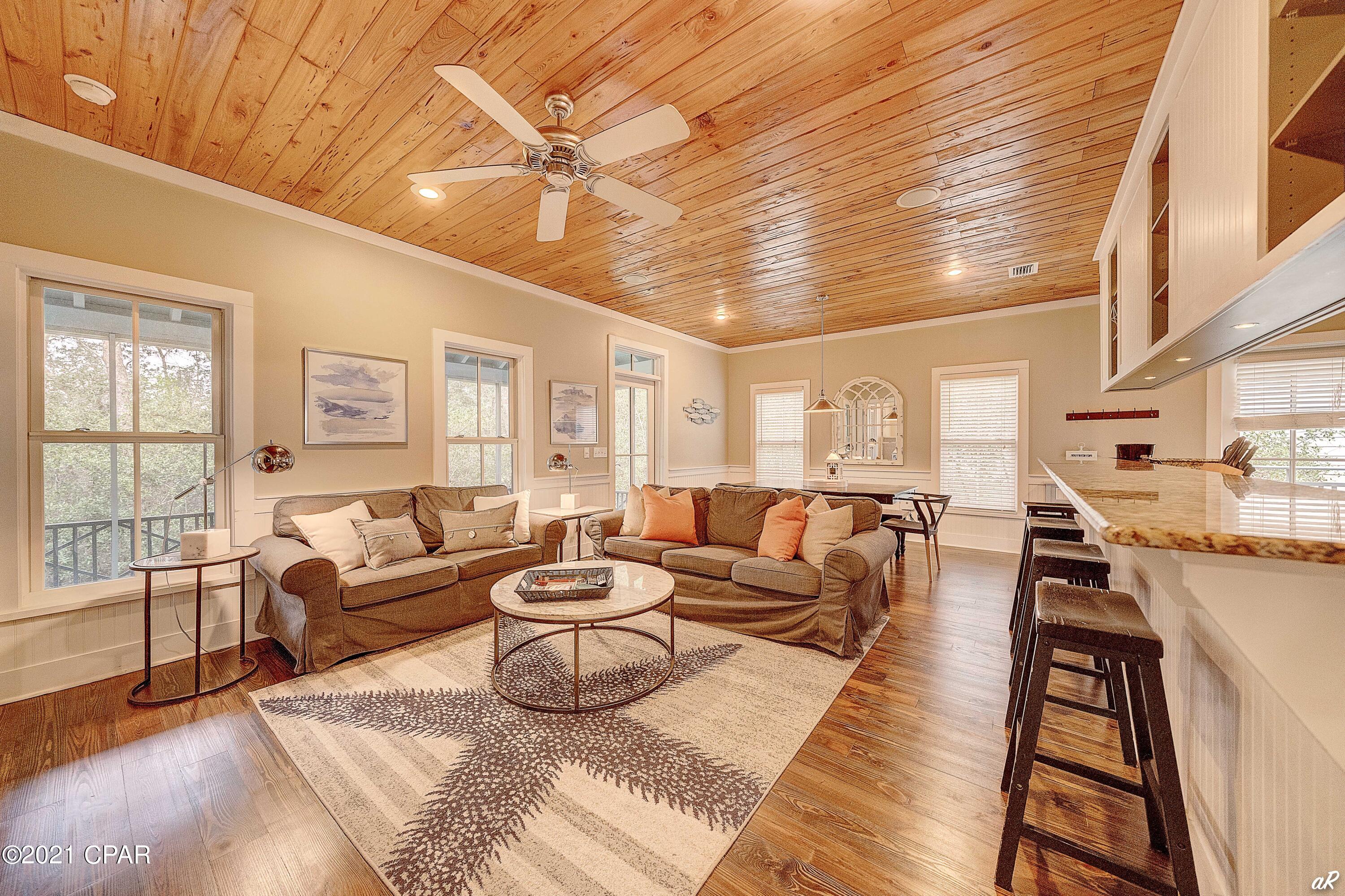 One of the lowest priced homes on 30a with deeded beach access. This stunning Florida Cottage is the most desirable floor plan, the Cedar Key floor plan. Beautifully constructed and primely located just steps from deeded beach access, this exceptional 1,225 square foot, three bedroom home features premium finishes with unparalleled interior design and professional decor. Characterized by Florida coastal cottage design, this charming coastal retreat makes the perfect secondary home with easy beach access and great short term rental opportunity (home easily sleeps 6 people). Notable features include custom wood ceilings, granite countertops, stainless steel appliances, washer/dryer included, hardwood floors, solid wood cabinets, weathershield windows and doors, outside shower, screened porch, and custom stored onsite storm shutters with quick connect fasteners.
The chef's kitchen masterfully anchors the spacious open floor plan and is finely appointed with a beautiful electric range, stainless appliances, custom cabinetry with ample storage as well as a sizable center island which is perfect for entertaining. The chef's kitchen is open to the gorgeous living room and dining area which feature custom lighting, custom built-in entertainment center, and plenty of seating. Other notable features include a large master suite as well as two additional bedrooms with their own private bathroom. Each room offers additional space for entertaining, and a private laundry which makes it perfect for multiple families gathering in one place. Situated on a nice sized lot with trees and foliage, this home is central to all of the world class amenities in Seacrest including the private Magnolia by the Sea pool, private/deeded beach access (both the beach and pool have private codes) as well as close proximity to many other activities with its eastern positioning.