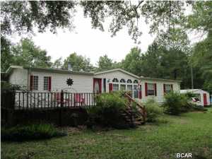 Beautifully maintained Triple Wide manufactured home on 10 manicured, country acres. The 2100+sf home is open and spacious. The rooms are HUGE! The pictures do not do this home justice, you need to see it to appreciate just how spacious this home is. Eat breakfast while watching the birds and squirrels feeding underneath the massive archway of Trumpet flowers and Jasmine. The enclosed deck is perfect for barbeques year 'round. Take a walk around your own pond filled with bream. Watch the deer eat at the back of the property. Nature galore! And located a block away from the Piggly Wiggly and Family Dollar. You'll only have to drive the 30 minutes to Panama City when you're needing some beach time. Make your appointment today!