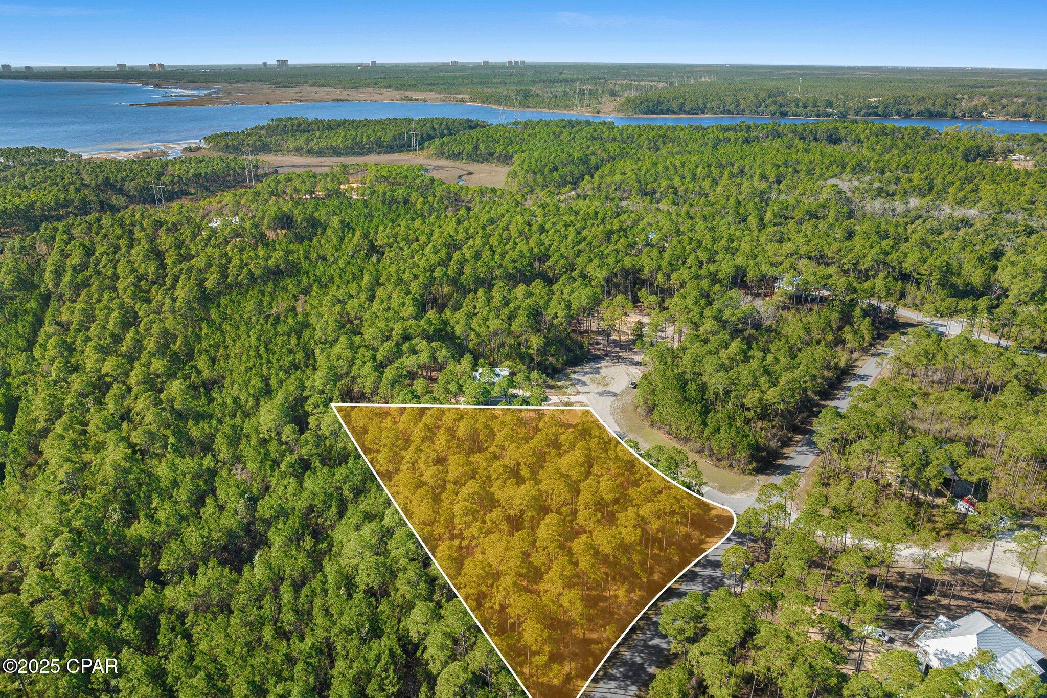 1.37-Acre Premium Homesite in RiverCamps - Build Your Dream Home! Discover the perfect canvas for your custom home on this expansive 1.37-acre corner lot in the exclusive RiverCamps at Crooked Creek community in Panama City Beach. Bring your vision to life or save time and money by taking advantage of already completed architectural plans from the Seller! 

This private residential community and wildlife sanctuary is truly one-of-a-kind and was designed with nature and water lovers in mind. Rivercamps is bordered by three sides of water with access to Crooked Creek, West Bay, and the Gulf. Over two thirds of the land is devoted to conservation. Residents enjoy the peace and quiet of 1,500 acres of woodlands preserve with less than 450 homesites. Enjoy unmatched amenities like unlimited use of kayaks and canoes for exploring, scenic nature trail system, fishing, campgrounds, resort style community pool, and dry boat storage and day-slips. Conveniently located 10 minutes from the NW Florida International Beaches Airport and 10 miles from white sandy beaches.