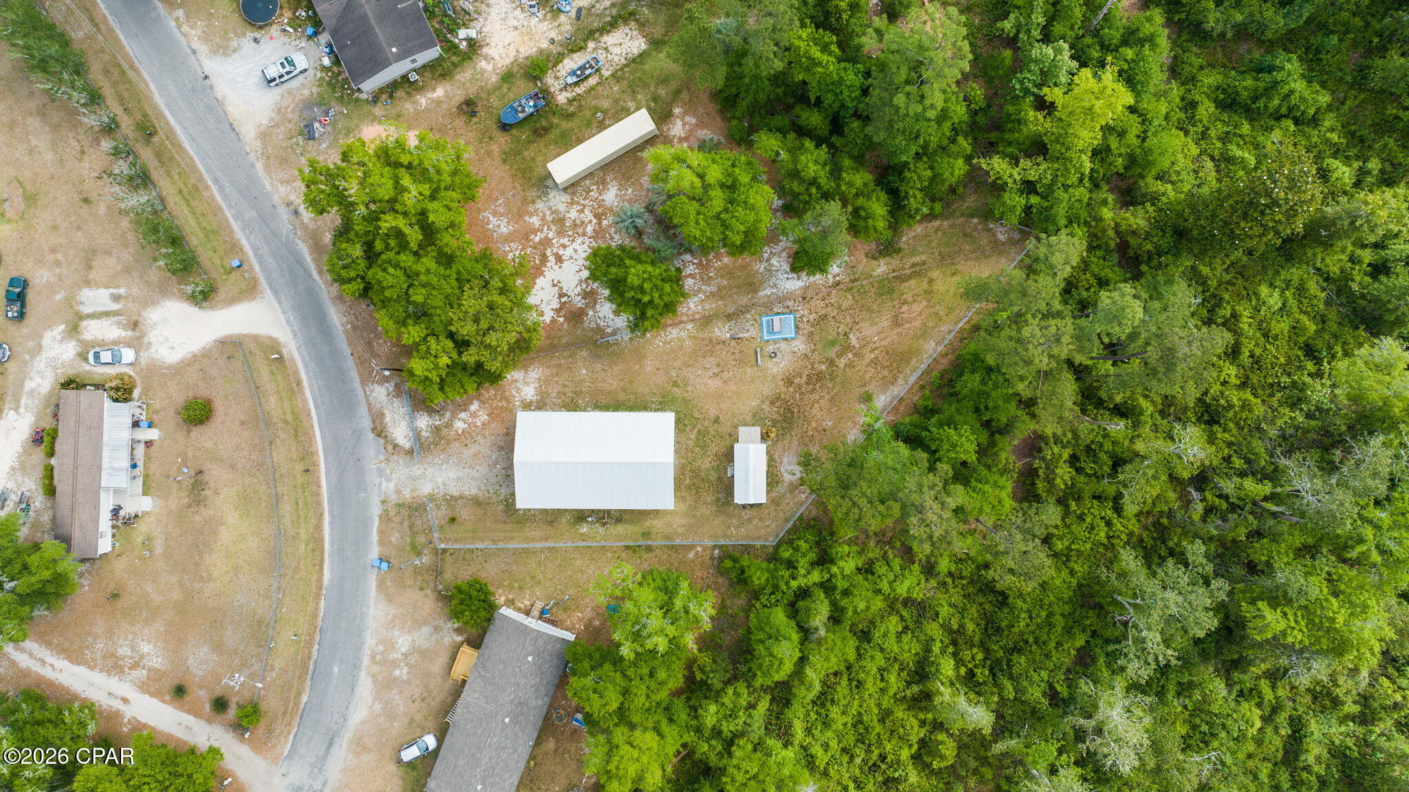 Tucked away beneath the trees in the heart of Wewahitchka, this one-of-a-kind property is built for the outdoorsman, weekend adventurer, or anyone craving a little more freedom and a lot more space. Situated across two parcels at 326 & 334 Pine Ave., this setup is ready to enjoy from day one with a fully covered RV pavilion, fenced grounds, utility hookups, and a 30ft Gulfstream motor home that conveys with the sale. The Motor home is a 2003 model and is in exellent condition.
The massive pole barn offers protection from the elements while creating the ultimate basecamp for hunting trips, fishing weekends, or laid-back living surrounded by nature. A powered workshop/storage building adds even more functionality for tools, gear, ATVs, or hobbies. Inside the RV, you'll find a surprisingly spacious and comfortable setup with warm wood cabinetry, a full kitchen, dining area, private bedroom, and full bath -- everything needed for a weekend retreat or full-time escape from the noise.
Surrounded by woods and wildlife, this property captures the true North Florida lifestyle. Spend your mornings drinking coffee under the pavilion, your afternoons exploring the nearby rivers, lakes, and trails, and your evenings around a fire under the stars. There's room here for boats, campers, toys, and all the gear that comes with living outdoors.
Whether you're looking for a hunting camp, recreational getaway, investment opportunity, or your own private slice of Old Florida, this property delivers the kind of setup that's hard to find and even harder to leave.