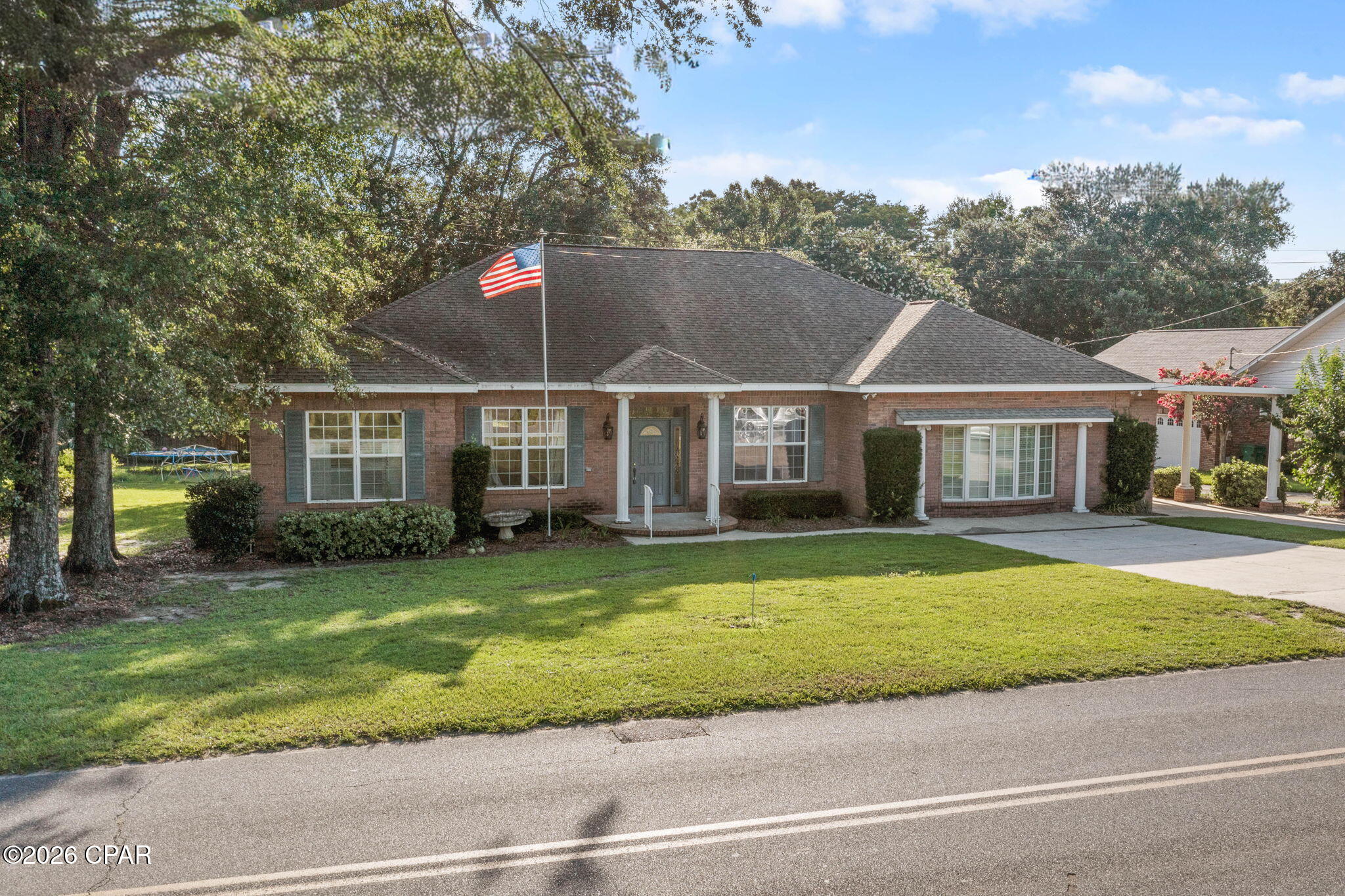Welcome to this well-maintained 3-bedroom, 2-bath home offering a spacious layout, quality finishes, and a convenient location in Graceville. Thoughtfully designed for comfortable everyday living, this home features inviting living spaces, abundant storage, and unique architectural details throughout. Step inside to a welcoming foyer that opens into the large living room with vaulted ceilings and a beautiful fireplace. Just beyond, the bright sunroom is lined with windows, creating the perfect place to relax while overlooking the backyard. The kitchen is designed with both function and style in mind, featuring custom cabinetry, stainless steel appliances, double wall ovens, large center island, generous counter space, and an abundance of built-in storage. A convenient wet bar with additional cabinetry makes entertaining easy. The primary bath offers dual vanities, a jetted soaking tub, a large walk-in tiled shower, and plenty of storage. Two additional bedrooms and a full guest bath provide comfortable accommodations for family or guests. Outside, you'll find even more to appreciate with an attached carport for everyday convenience, as well as a detached garage/workshop offering excellent space for parking, hobbies, storage, or projects. The private backyard provides plenty of room to enjoy the outdoors while still being easy to maintain. Conveniently located in Graceville just minutes from the Baptist University of Florida, this home combines generous living space, distinctive custom features, and a location that's close to schools, shopping, and everyday conveniences.