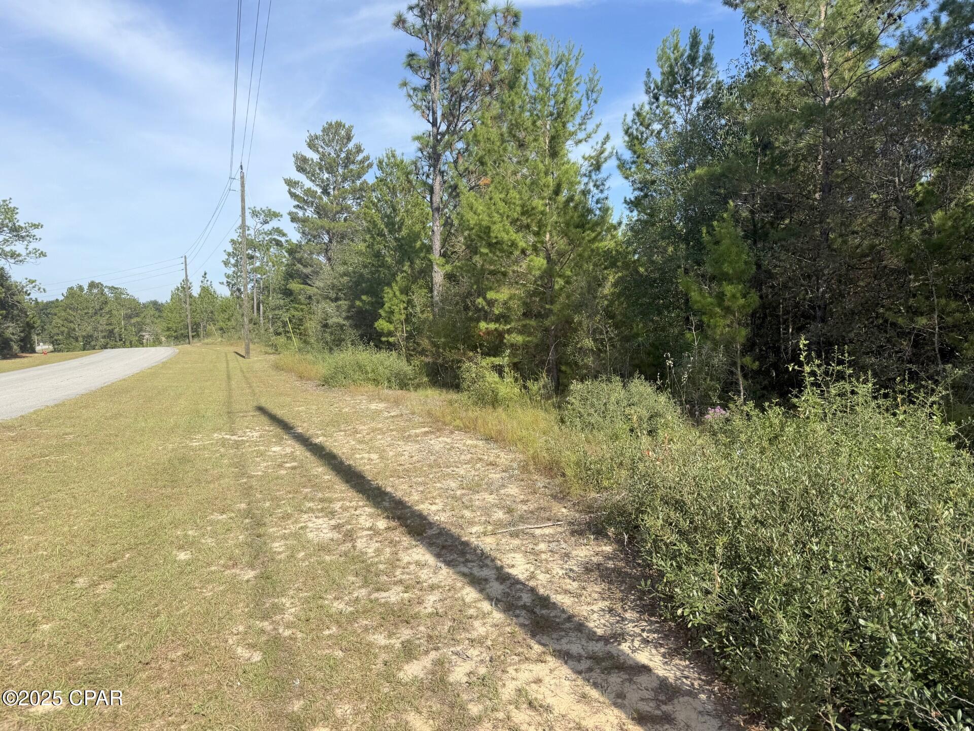 Nestled along a paved road in the Sunny Hills community, this wooded lot provides the ideal backdrop for your future dream home! Enjoy community amenities such as an 18-hole golf course, the picturesque Boat Lake, and a variety of nearby fishing opportunities. Just 43 miles from Panama City Beach, famous for its sugar-white sand and emerald waters, you'll experience the tranquility of small-town living with easy access to one of Florida's top coastal destinations. Adjoining lot for sale also.