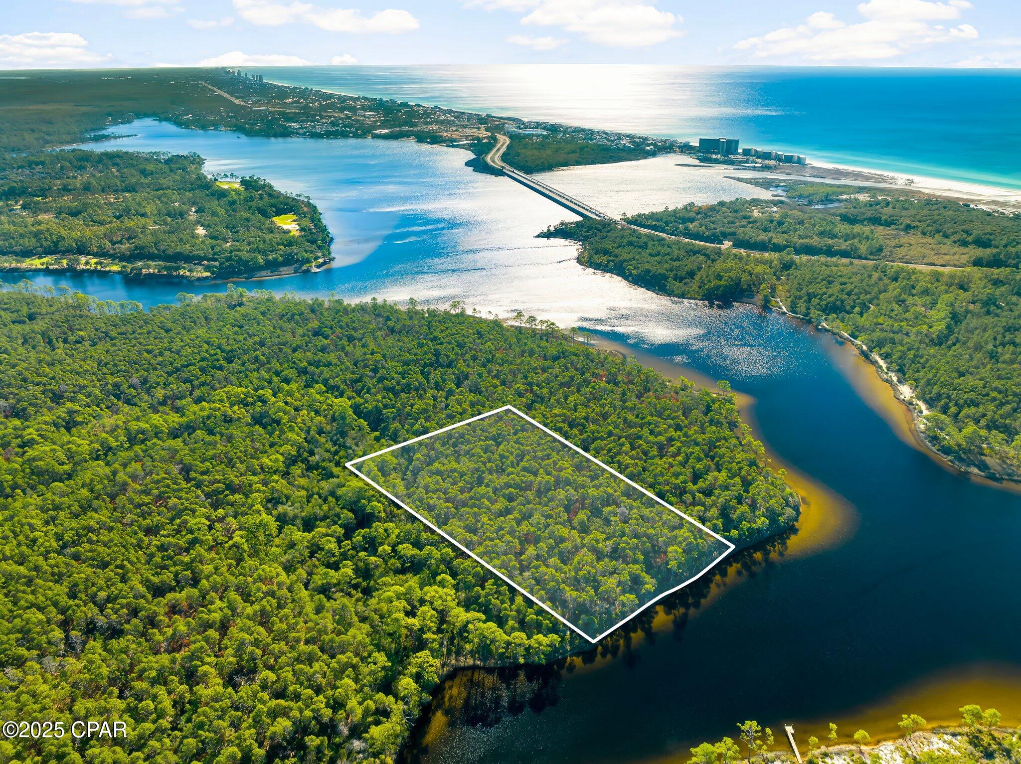 Rare Waterfront Opportunity: 5.58-Acre Powell Lake Parcel with ~300' Pristine Shoreline - Panama City Beach Area.

Tucked in a peaceful northwestern cove of Powell Lake--Florida's (and North America's) largest coastal dune lake at nearly 800 acres--this expansive 5.58-acre lot offers a truly one-of-a-kind canvas amid Northwest Florida's evolving landscape. Designated as an 'Outstanding Florida Waters' gem, the lake's brackish ecosystem supports exceptional boating, jet skiing, paddling, and wildlife viewing, with enhanced public access via Bay County's self-service kayak kiosk at the nearby boat ramp.

Boasting approximately 300 feet of direct, serene shoreline, this property delivers unmatched privacy and natural beauty--perfect for envisioning a custom waterfront retreat, eco-lodge, family compound, or long-term hold in a region where true lakefront acreage grows scarcer by the day.

Strategically positioned between the prestigious gated communities of Watersound Origins and Wild Heron, you're steps from resort-style amenities: Greg Norman-designed Shark's Tooth Golf Course, pools, nature trails, and more. Panama City Beach's west-end growth continues strong into 2026, with ongoing developments, new attractions (Topgolf, Pirates Voyage), shopping, and dining just minutes away--boosting lifestyle and investment upside.

Note on Access: This parcel is currently without legal road ingress/egress (water access only via the lake), a known condition reflected in the pricing and history. Ongoing regional dynamics--including potential future interest from major landowners like St. Joe Company--could open pathways for resolution, but buyers should conduct due diligence on access options, easements, or water-based use.

In a market where coastal dune lake shoreline is increasingly prized, this blank-slate waterfront rarity stands out for visionaries ready to explore its potential. Priced to reflect the unique circumstances--don't miss your chance to own a piece of this irreplaceable Emerald Coast treasure.