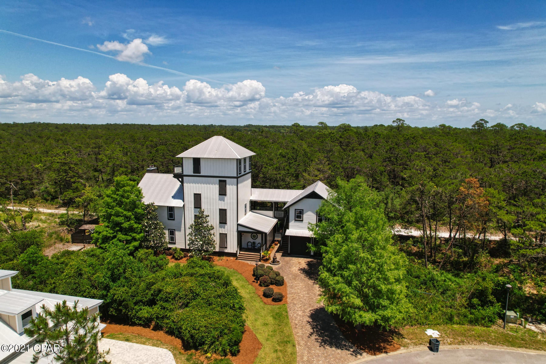CURRENTLY UNDER CONTRACT, SELLER ACCEPTING BACKUP OFFERSCome see this stunning, custom-built property ideally situated within the highly desirable Grande Pointe community.  Sitting on a large corner lot that backs up to Camp Helen State Park, this expansive 4 story, 5 bedroom home features an elevator and boasts a large mother-in-law suite fully contained above the garage.  Inside the residence you'll find numerous features.  The second floor master suite offers a walk-in closet, separate dressing area, private bath w/ double vanity and a private balcony overlooking the state park.  Downstairs you'll find an open kitchen that flows into the living and dining area.  If you want to host and relax outdoors, there is a large screened porch complete with a wet bar and fireplace. To top it off, head to the 4th story deck to watch the sunset.  The community offers a beautiful pool and clubhouse with a dock.   Buyer to verify square footage/ parcel and all measurements