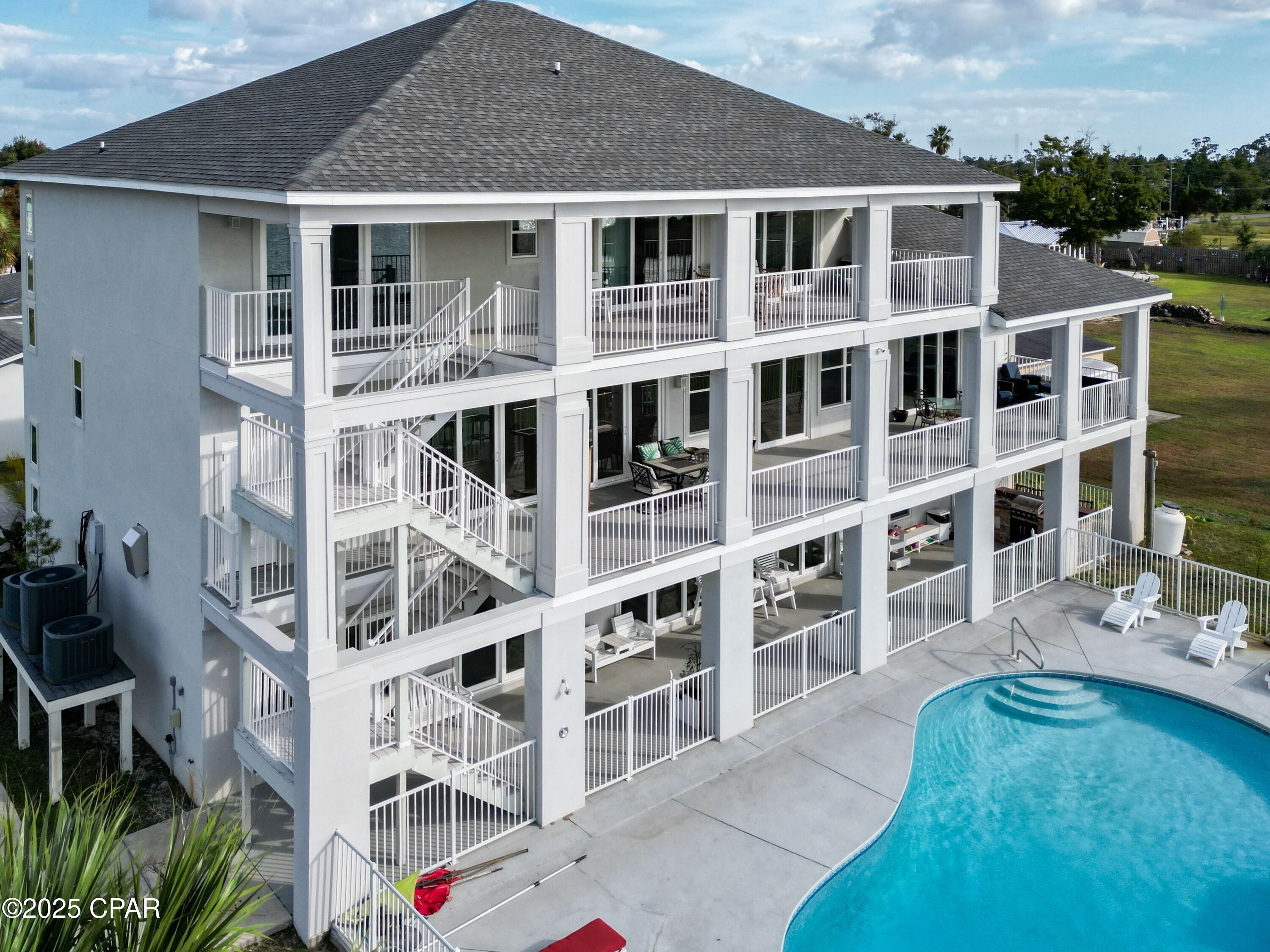 Welcome home to this North Bay-front custom resort style property. Delight in the view of the bay and spectacular sunsets from almost every room. Watch the dolphins jump while you enjoy morning coffee on the oversized 2nd or 3rd floor balconies. In addition to the balconies, there is a large covered lanai that span the entire length of the house. 
The lush landscaping, sparkling pool, custom summer kitchen and private 2 level, 2 boat-slip dock make this the perfect Florida home. The sizable lot is ideal for weddings or large get-togethers. Entertaining is a breeze with a full kitchen on the first floor in addition to the primary oversized kitchen on the second floor. If that isn't enough, there is a wet bar (second floor) and a kitchenette (third floor).  Fireplaces are in the owner's suite and the flexible area, both on second floor. The bedroom on the first floor is currently being used as a theater room. The living room on the first floor is being used as a recreational space. The possibilities are endless!!!!!
No worries about climbing stairs. The elevator is conveniently located in the front foyer. Storage is abundant. There are two double car garages, 4 garage spaces total.  Every bedroom has a large closet. There are numerous multi-purpose closets/storage rooms throughout the home. This home has a newer roof (Fall 2023).  
Ask your Realtor for a list of the recent upgrades located in the documents). They are too numerous to list here.
 You will be a hero to family and friends when you make this resort style pool/bayfront home your own.
210 Montana Ave is an adjacent property that is deeded separately. The buyer of 212 Montana Ave has the first option to purchase this home. 
The description is 1798 square feet, 4 bedrooms, 2 full baths, 2 living rooms, and a 3 car detached garage. The garage includes 2 car spaces and 1 golf cart space.  This property was fully renovated in 2020.