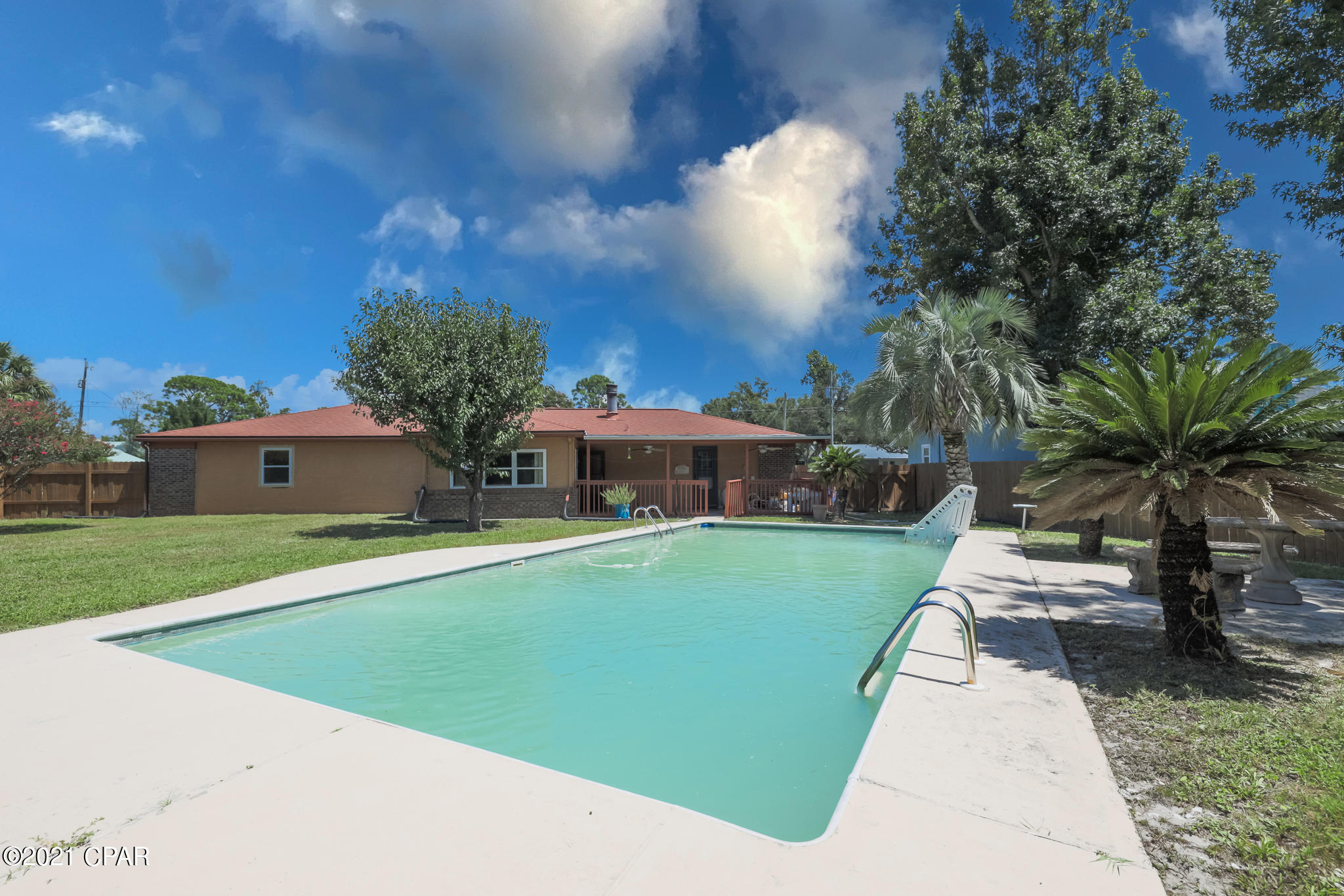 Large 4-bed/2bath house with inground POOL on an oversize lot on a quiet street in the North Lagoon area of Panama City Beach, Florida! Only a 5-Minute drive from grocery stores, the beach, and all the best restaurants in town! Featuring a living room with a fireplace and sliding glass doors to the heated and cooled sunroom outfitted with a bar. Dining room with bay windows facing the front yard adjacent to the kitchen. All bedrooms are situated on the north side of this custom-built home. The dwelling with an attached 2-car garage sits on a large lot with a privacy-fenced backyard and pool. All measurements are deemed correct, buyer should verify if they are important.