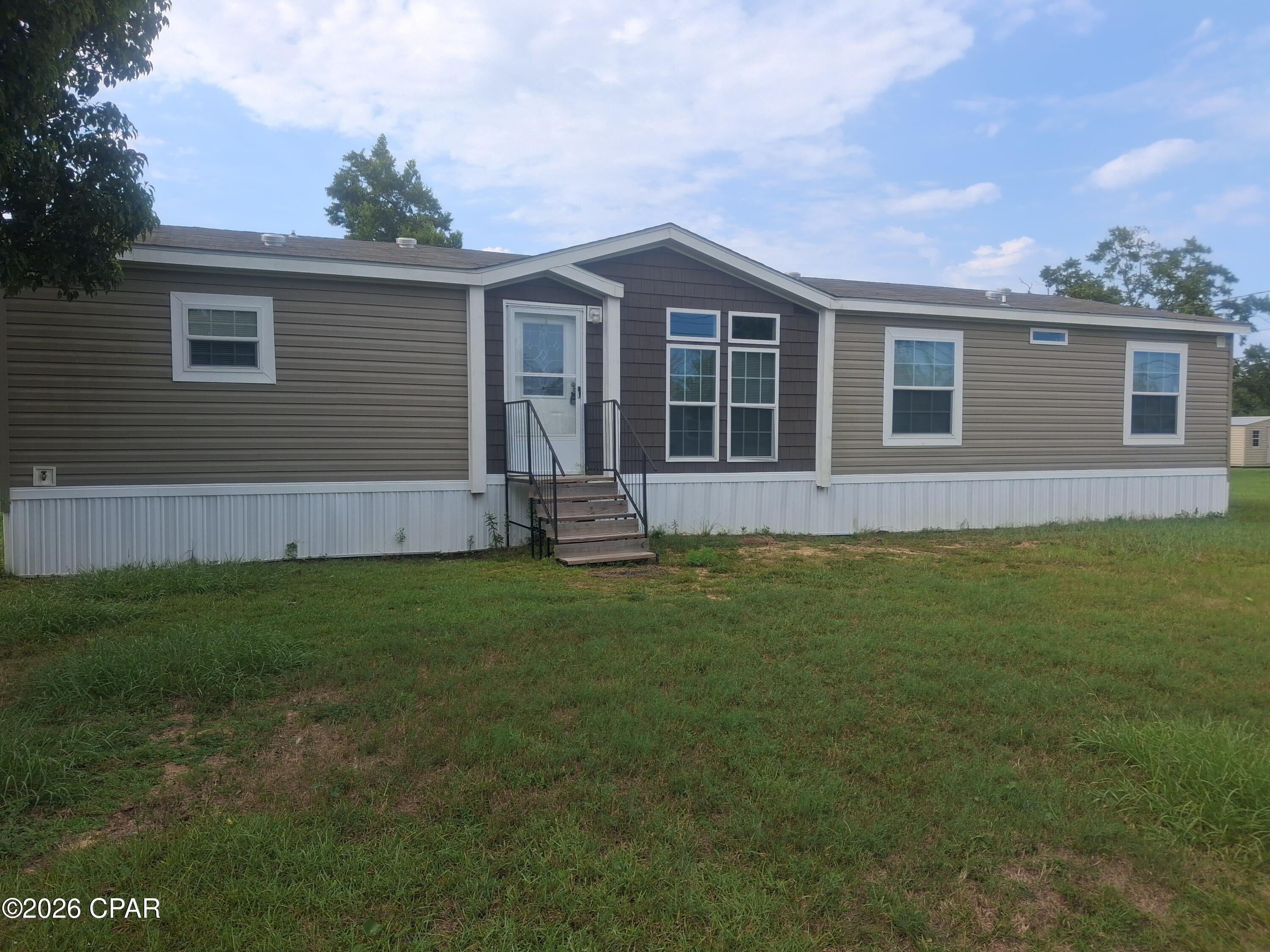 Spacious living with plenty of room to enjoy the outdoors! Located on just under an acre in Panama City, this 4-bedroom, 2-bathroom manufactured home offers approximately 1,888 heated and cooled square feet with a comfortable layout and plenty of space for the whole family.

Inside, the home features a large kitchen with a center island, abundant cabinet space, and plenty of room for meal preparation and entertaining. A formal dining room provides a dedicated space for family dinners and special occasions, while the spacious living areas offer plenty of room to relax.

The large master suite is a true retreat, featuring a generous walk-in closet and a private master bathroom with a double vanity, walk-in shower, and corner soaking tub. The additional guest bedrooms are also generously sized, providing comfortable accommodations for family, guests, a home office, or other needs.

Step outside and enjoy the extra space this property provides. The covered back porch is ideal for relaxing in the shade, while the large open back deck offers additional room for grilling, entertaining, or enjoying the outdoors. With nearly an acre of land, there's plenty of room to create your own outdoor oasis.

Conveniently located in Panama City, this property offers a great combination of space, comfort, and a larger-than-average homesite, while remaining close to shopping, dining, schools, medical facilities, and the many attractions of the Florida Gulf Coast.

If you're looking for a spacious 4-bedroom home with nearly an acre of land and great indoor and outdoor living space, 5036 E. 14th St. is worth a look. Schedule your private showing today!