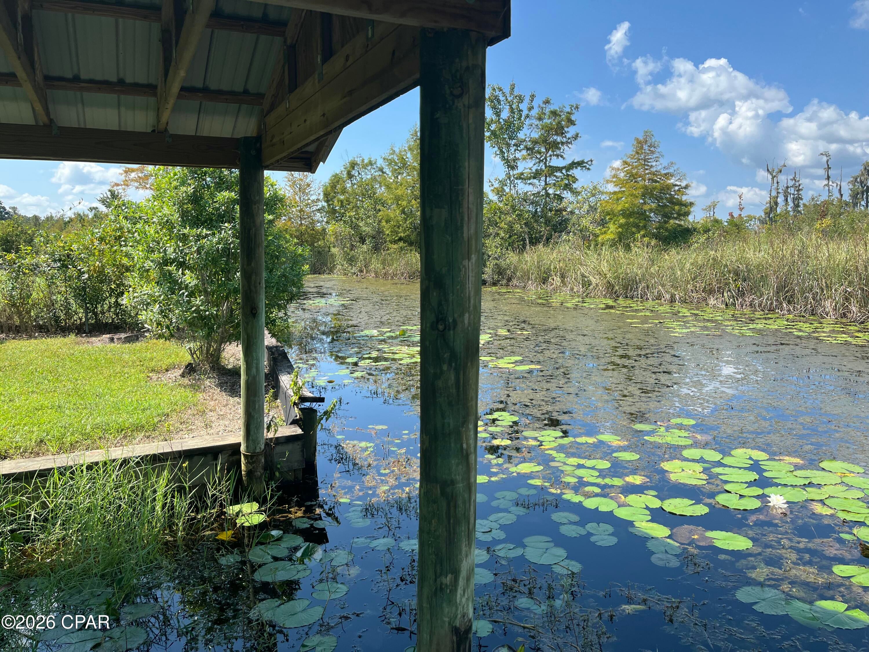 Live your waterfront dream on this perfectly situated deepwater (year round!) lot, just a 5 minute boat ride to DEER POINT LAKE or ECONFINA CREEK. This BEAUTIFUL 1.06 acre lot offers stunning LAKEFRONT VIEWS along with a quiet neighborhood of newer homes, perfect for your custom house!  This large lot with NO HOA's allows you plenty of freedom to build your perfect home, and offers the bonus of a 1994 MOBILE HOME ON SITE! While there are NO MOBILE HOME TITLES to transfer , the home includes 2 bedrooms/ 2 bathrooms, kitchen and Laundry room. Imagine the convenience of using it while you build your future home! In addition, this property has lots of storage for BOATS (Boathouse) , MOTORHOMES, and all your toys! 
If your idea of paradise includes FISHING,BOATING,KAYAKING, BIRD WATCHING, all from your own backyard, don't miss this opportunity to have your own peaceful retreat!
