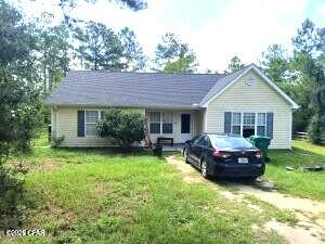 Very nice home situated on 1.1 acres, has a 2-car carport with a concrete walkway to a large back porch. You will enter the back door into the kitchen area. The carport has a 4x20 room in the back for storage currently used as a dog area with a doggie door going out into a chain link dog yard. The property is outlined with a nice looking 3 board fence. There is lots of shade in the front and back yard with plenty of room for more out buildings or for housing some farm animals. The house has tile floors throughout in all the rooms for easy cleaning and maintenance. Two nice full-size bathrooms, master has a separate stand-up shower and a tub with a nice window for relaxing. Home is approximately 1 mile from fire dept and close to Compass Lake with public boat ramps. You also have the option to join the HOA which will give you access to a community swimming pool, driving range, disc golf, cabins and more. The HOA is optional and roughly 150.00 a year.  The property is approximately 55 miles to Panama City and the beach, 35 miles to Dothan AL and 10 miles to I-10. Stove, refrigerator, washer and dryer stay. Central heat and air but does need recharging according to the seller.