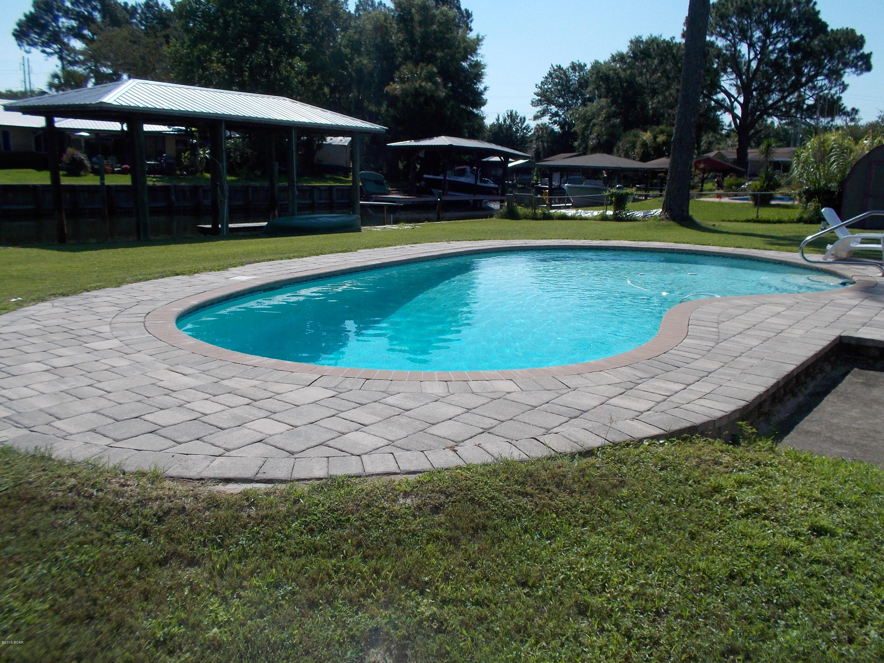 This is the home!  Not only is it on a canal with a boat house & lift accommodating up to a 34 ft boat & has a fish cleaning station.  It also has a sparkling in-ground swimming pool beautifully decorated with stone pavers around the deck.  The yard is meticulous with lush grass and landscaping.  The home has been very well cared for and maintained.  A new metal roof was put on in 2009.  A new 440 ft. well installed in 2012 and a totally new septic and drain field in 2008.  Other than cosmetic updates to make it your own, this home is ready to move into and enjoy.  The rooms throughout are all nice sizes, much bigger in size compared to most newer homes.  No trouble fitting your furniture.  And your family will be delighted with the view from the extra large windows and glass doors!