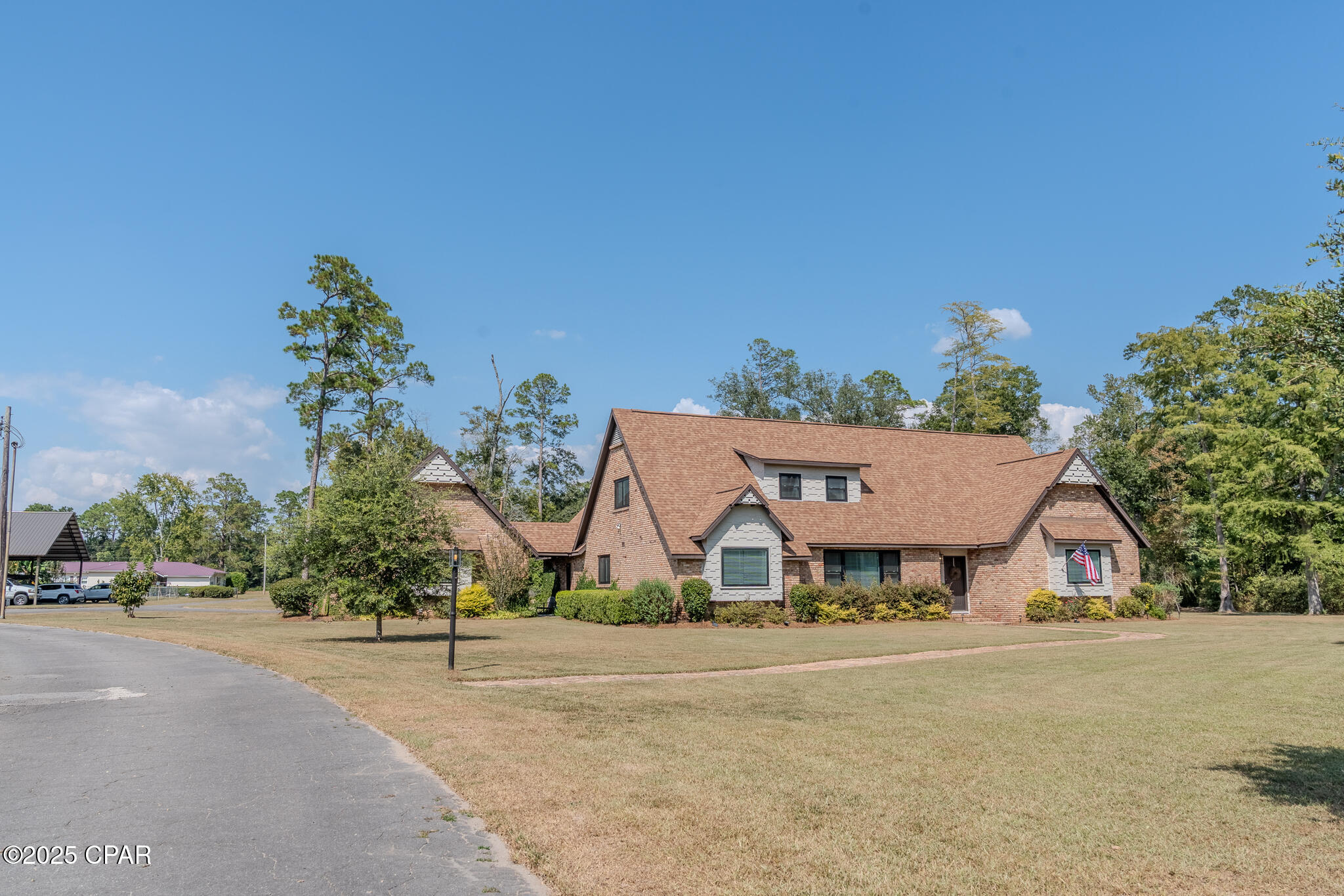 Located in the heart of Graceville, Florida across from Lake Albert and affectionately known as ''the Doctor's House'', this custom built, mid-century modern estate is a 2 story, 4000+ square feet, 4 bedroom/3.5 bathroom brick home on a sprawling 2.45 acres. With modern updates and original charm, the spacious floorplan features a formal living and dining room, open concept family room/den with a bar, breakfast nook and fireplace, private office with separate entrance, game/play room above the 2 car garage, large kitchen, pantry and laundry room and tons of storage. The exterior is lovely brick with a deep gable roof and matching walkways and accents surrounded by traditional Southern landscaping including azaleas, muscadine, old and new live oaks, pine, pecan, cypress, willow and fruit trees. The acreage includes a wet weather creek with bridge, 36 x 48 pole barn, 50 amp RV hookup and pad, private well, front and rear driveway access, dog pen/chicken coop, fire pit, back porch and breezeway and great outdoor living spaces. This is the perfect place to spread out, entertain and enjoy serene country living in a quiet neighborhood, convenient to town. This lovely piece of paradise is turnkey and ready for move in just in time for the holidays.