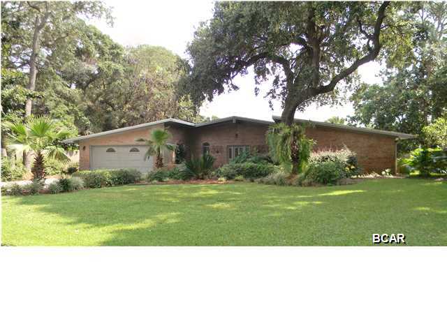 OWNER MOTIVATED - BRING OFFERS!! GRAND LAGOON WATERFRONT HOME w/Gulf & Bay Access by Boat! 105 feet on the water located on private & quiet street tucked away just off of North Lagoon Drive - 1/2 acre lot. 10 minutes to the Gulf of Mexico by boat and 5 minutes to the beach by car!! Huge outdoor living space w/ Screened Lanai & Heated Pool. Covered Boat Dock w/10,000lb Lift, water & power - deep water channel in this location. This meticulously maintained home has panoramic views of the water! Highlights include authentic terrazzo floors, HUGE 20'x 20' kitchen with double islands, granite countertops, tons of cabinets, wood burning fireplace, 4th bedroom has been converted into a large office & can easily be converted back if needed, vaulted ceilings & skylights create abundant natura