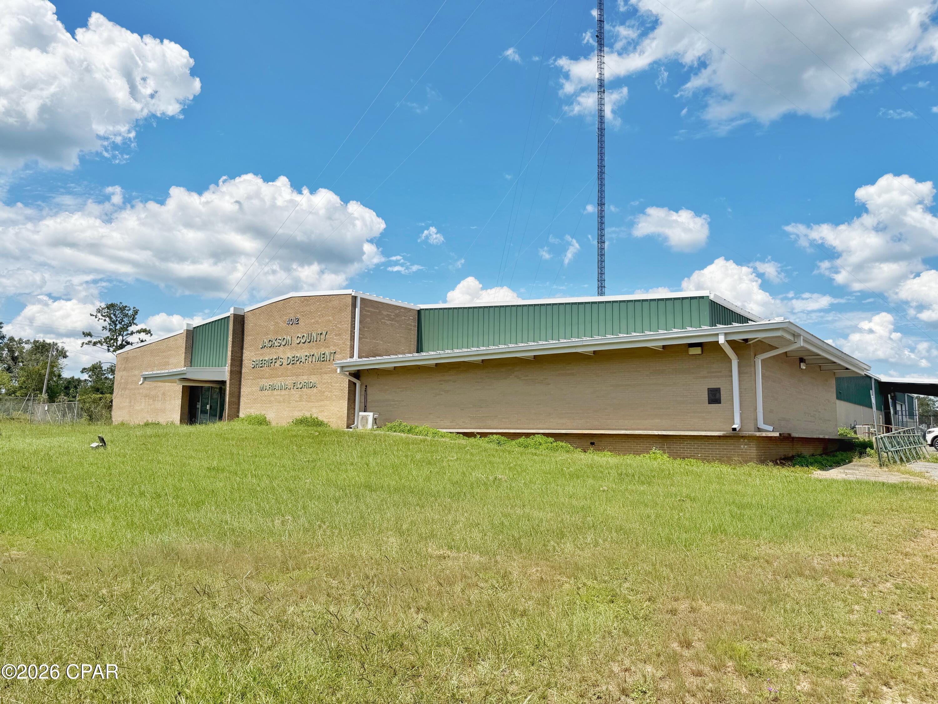 Exceptional opportunity to acquire a substantial move-in-ready commercial facility situated on 6.32 acres with prominent frontage along highly traveled U.S. Highway 90/Lafayette Street in Marianna. Offering an impressive 24,676 heated and cooled square feet, this expansive property provides the space, infrastructure and flexibility to accommodate a wide variety of commercial, institutional or governmental uses.

The thoughtfully designed interior features dozens of private offices, multiple large meeting and conference rooms, a spacious central front lobby/reception area and multiple restroom facilities throughout the building. The existing layout makes this an outstanding option for an organization needing significant administrative or operational space without the time and expense of a major build-out.

Storage and operational capabilities further distinguish the property. One room is already equipped with high-density rolling file storage cabinets, while a central locker/storage area is conveniently positioned along the rear hallway. Back-door access connects the building to an enclosed and fenced secure storage area with roll-up doors, previously utilized for evidence storage. An additional pole barn at the rear of the property provides even more covered storage and utility space.

Outside, the property's 6.32-acre site provides substantial room for parking, secured operations, storage and potential future expansion, subject to applicable zoning and approvals. Its location directly on U.S. Highway 90/Lafayette Street, one of Marianna's primary commercial corridors, offers excellent accessibility and visibility.

With nearly 25,000 square feet of conditioned space, extensive office and meeting facilities, secure storage capabilities, abundant acreage and a strategic Highway 90 location, this is a rare opportunity for a corporate headquarters, governmental agency, medical or administrative facility, educational or training center, nonprofit organization, professional office complex or other large-scale commercial user.

Move-in ready and exceptionally versatile--this is a property that would be difficult to replicate at this scale.