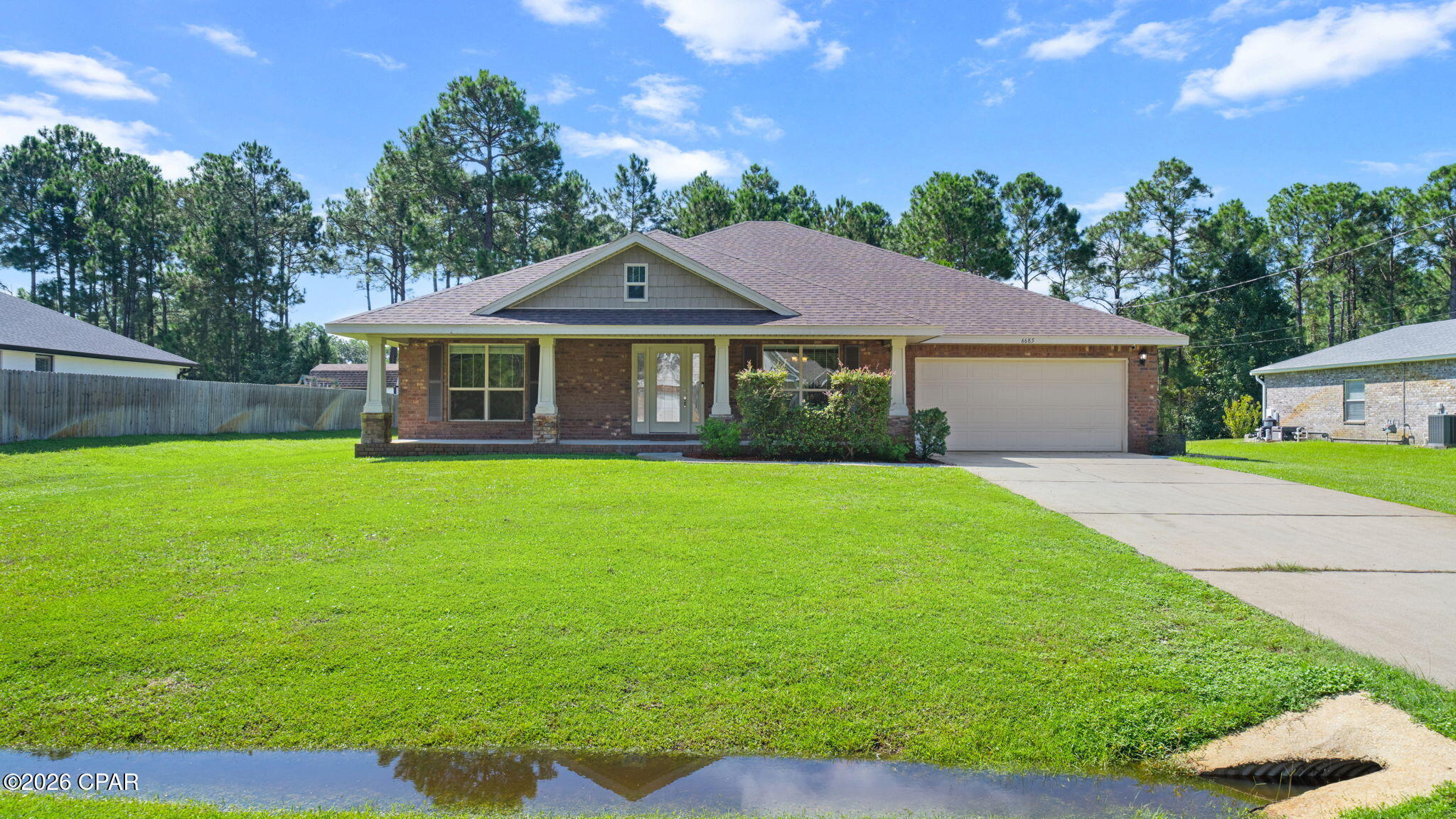 Welcome home to this spacious 5-bedroom, 3-bath brick home offering 2,705 sq. ft. of comfortable living space in the desirable Holley by the Sea community of Navarre. Situated on just under half an acre, this move-in-ready home offers plenty of room inside and out. The open living area features high ceilings and a fireplace, while the kitchen offers granite countertops, abundant cabinetry, stainless steel appliances and generous workspace. Enjoy Florida living from the large covered back patio overlooking the spacious backyard. Community amenities include a pool and tennis courts, with Navarre Beach just a quick drive away. Located in a quiet residential setting while remaining convenient to shopping, dining, recreation and the beautiful Gulf Coast. With five bedrooms, three full baths, an attached garage and plenty of outdoor space, this home is ready for its next owner.