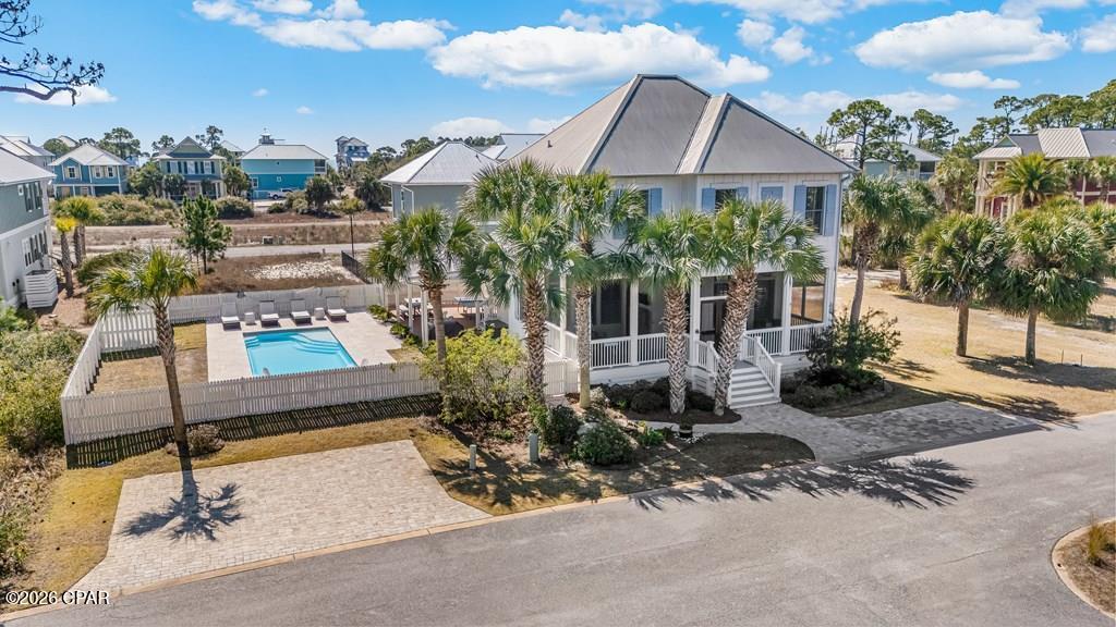CUSTOM BUILT WITH PRIVATE POOL. This home sits on two full lots, a rare find that offers extra space, privacy, and an elevated coastal lifestyle in the gated community of Jubilation. Designed with true indoor-outdoor living in mind, the heart of the property is the heated pool, surrounded by travertine decking, fire pit, paver walkways, outdoor seating areas, and a fully fenced backyard framed by mature palms. A covered patio and screened in porch, with television, create multiple spots to gather, dine, or unwind after a day at the beach. Inside, thoughtful craftsmanship is evident throughout. Bamboo flooring runs through the main living spaces, highlighted by 12' ceilings, while the dining area features a warm pine ceiling detail that adds character and charm. The kitchen was designed for both entertaining and everyday living, complete with granite countertops, custom wood cabinetry, a spacious island with seating, pot filler, double wall oven, pendant lighting, and a double undermount sink. The main-level primary suite offers a peaceful retreat with a walk-in closet, soaking tub, and beautifully tiled custom shower. Each guest bedroom includes its own private bath, giving family and guests comfort and privacy. Additional features include three-zone HVAC, whole-home wired sound, Andersen windows, 8' solid interior doors, three solid mahogany entry doors, and custom barrel gutters. A paver driveway and screened entries enhance both curb appeal and function. Jubilation owners enjoy access to a Gulf-front community pool and deeded beach boardwalk. Loggerhead Run/Bike Path right outside of the gates is perfect for biking, walking and just minutes away is Salinas Park which offers pickleball courts, playgrounds and launching a kayak into the bay. Schedule your private tour today!