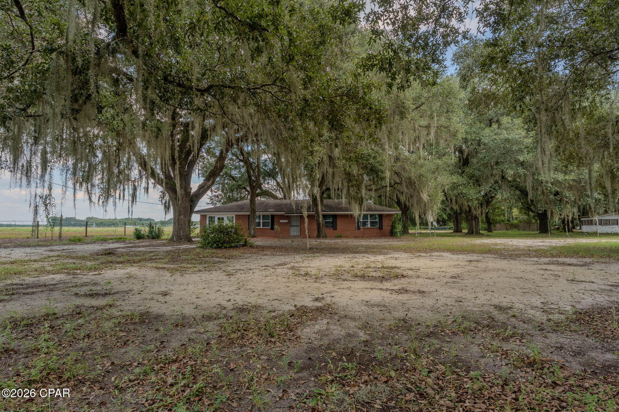 Escape to the tranquility of the country with this solid three-bedroom, two-bath brick home situated on a sprawling 2.20 acres. The property is a nature lover's dream, featuring mature oak trees draped in iconic Spanish moss that provide a beautiful, shaded canopy and ultimate privacy.

Inside, the open-concept living and kitchen area creates a warm and inviting space perfect for family gatherings or quiet evenings at home. The home also boasts a 325 sq ft versatile bonus space--the converted garage now serves as a convenient laundry room and storage area, while also offering a bright Florida room ideal for a home office, playroom, additional bedroom or sunlit sitting area.

Located in the peaceful countryside of Malone, Florida, this property offers the perfect blend of rustic charm and practical living. Don't miss your chance to own a slice of Southern serenity!
