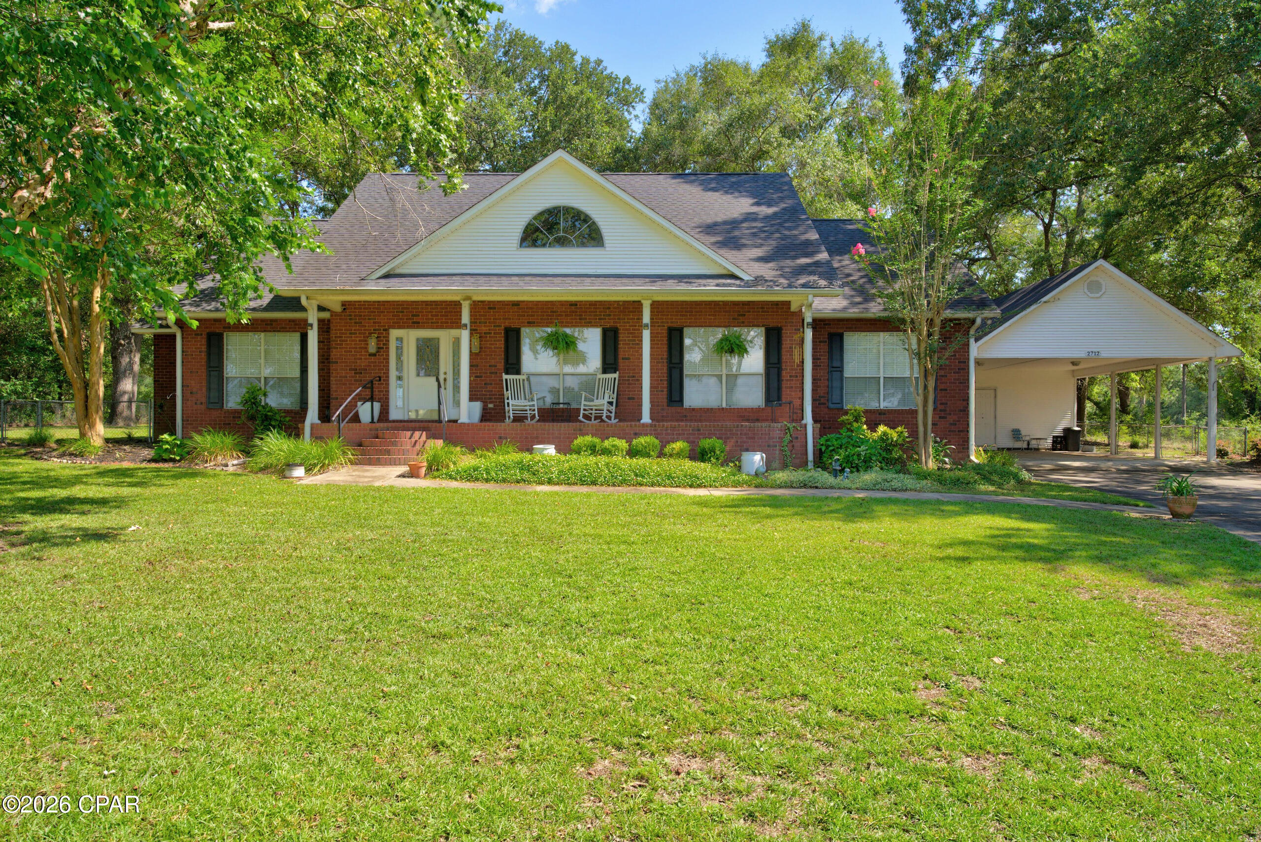 Welcome to 2712 Marian Drive, a beautifully maintained brick home located in the desirable Dogwood Lakes Golf Community in Bonifay, Florida. Situated on a spacious 0.7-acre lot with no HOA, this property offers peaceful lake views, golf course scenery, and the quiet charm of a low-traffic neighborhood. A canopy of shade trees provides privacy from the first fairway while still allowing you to enjoy the beautiful surroundings.

This spacious 3 bedroom, 2.5 bathroom home offers approximately 2,203 heated and cooled square feet with over 2,700 square feet under roof. Inside, you are welcomed by a foyer leading into the large living room featuring vaulted ceilings and a wood-burning fireplace. Double doors open to a bright Florida room with windows on all sides, creating a wonderful space to relax and enjoy views of the property.

The kitchen features wood cabinetry, solid surface countertops, built-in appliances, a gas cooktop, in-wall oven, microwave, and an eat-in bar connecting to the dining area. An additional room off the dining space provides flexibility for a home office, den, hobby room, or formal dining area. The spacious primary suite includes a double vanity, walk-in shower, separate jetted tub, and walk-in closet, while the two additional bedrooms share a convenient Jack-and-Jill style bathroom layout. A half bath is located off the foyer for guests.

Outside, the fenced backyard, deck, oversized double carport, and attached enclosed workshop provide plenty of room for outdoor living, storage, hobbies, and entertaining. With room to add a pool, garden, or additional workspace, this property offers space to truly make it your own. Recent updates include roof, water heater, deck, and more. Schedule your private showing today to see all this lake view golf course home has to offer.
