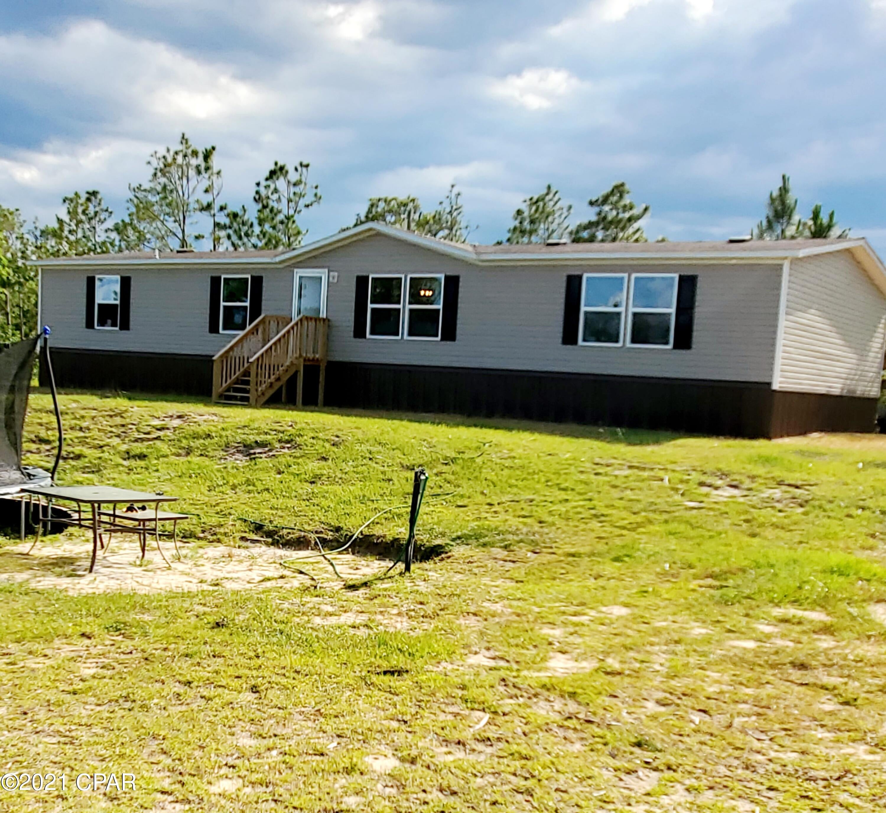 Beautiful 20 ACRES of private country living with a 1,768 sq. foot 2020 Manufactured Home, 31X24 Metal Barn and large pole barn!   This 20 acres is fenced and has pasture area and timber.   This almost new 4 bedroom home has a Separate Living Room and large Family room.  Master bedroom has extra large walk in closet and large master bath.  Split floor plan gives lots of space for 3 more bedrooms and nice guest bath.  Lots of extras were added to this home.  So much space outside for gardening, hunting, or a hobby farm.  No restrictions!  Horses are welcome.  Call today and let us show you this great home located close to Marianna and about 30 mile north of Panama City.