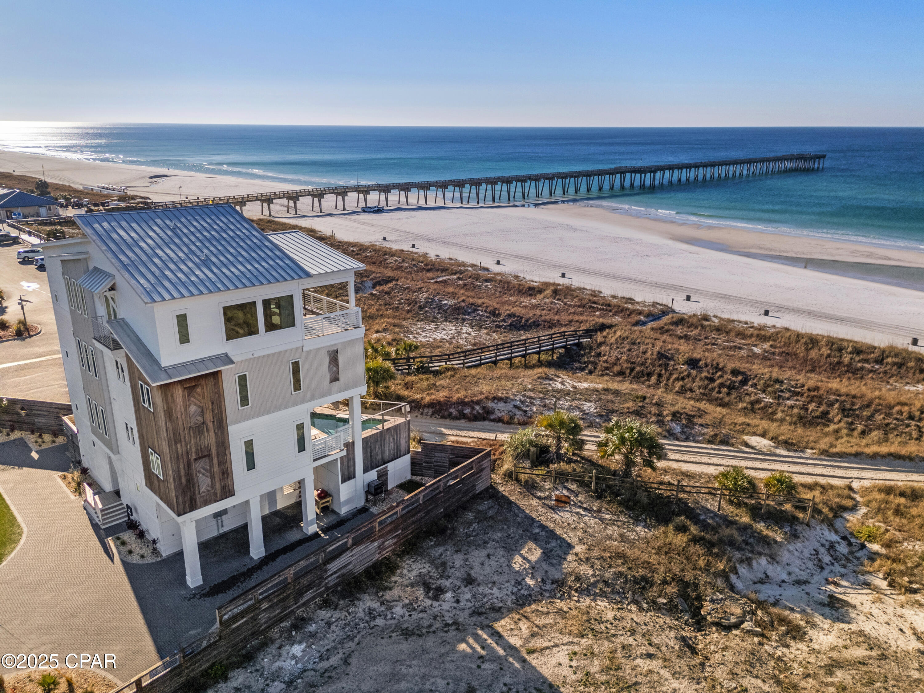 MASSIVE PRICE REDUCTION, HIGHLY MOTIVATED SELLER!! Find coastal luxury with this magnificent 6 bedroom/6 bathroom 2 half bath beachfront retreat, designed to accommodate up to 16 guests in unparalleled comfort. Nestled against the shoreline, this haven offers an array of exceptional amenities that promise an unforgettable escape. Immerse yourself in the allure of outdoor leisure with a dedicated lawn game area featuring foot pool, cornhole, and mini golf. A symphony of style awaits within, where each corner is adorned with tasteful décor. A fully equipped kitchen and a convenient kitchenette cater to your culinary desires, ensuring every meal is a delight. There is an indoor elevator equipped in this home to help quickly and conveniently navigate between floors. This beachfront gem also showcases private walkout balconies with soothing Gulf views on every floor, accessible from each bedroom.
