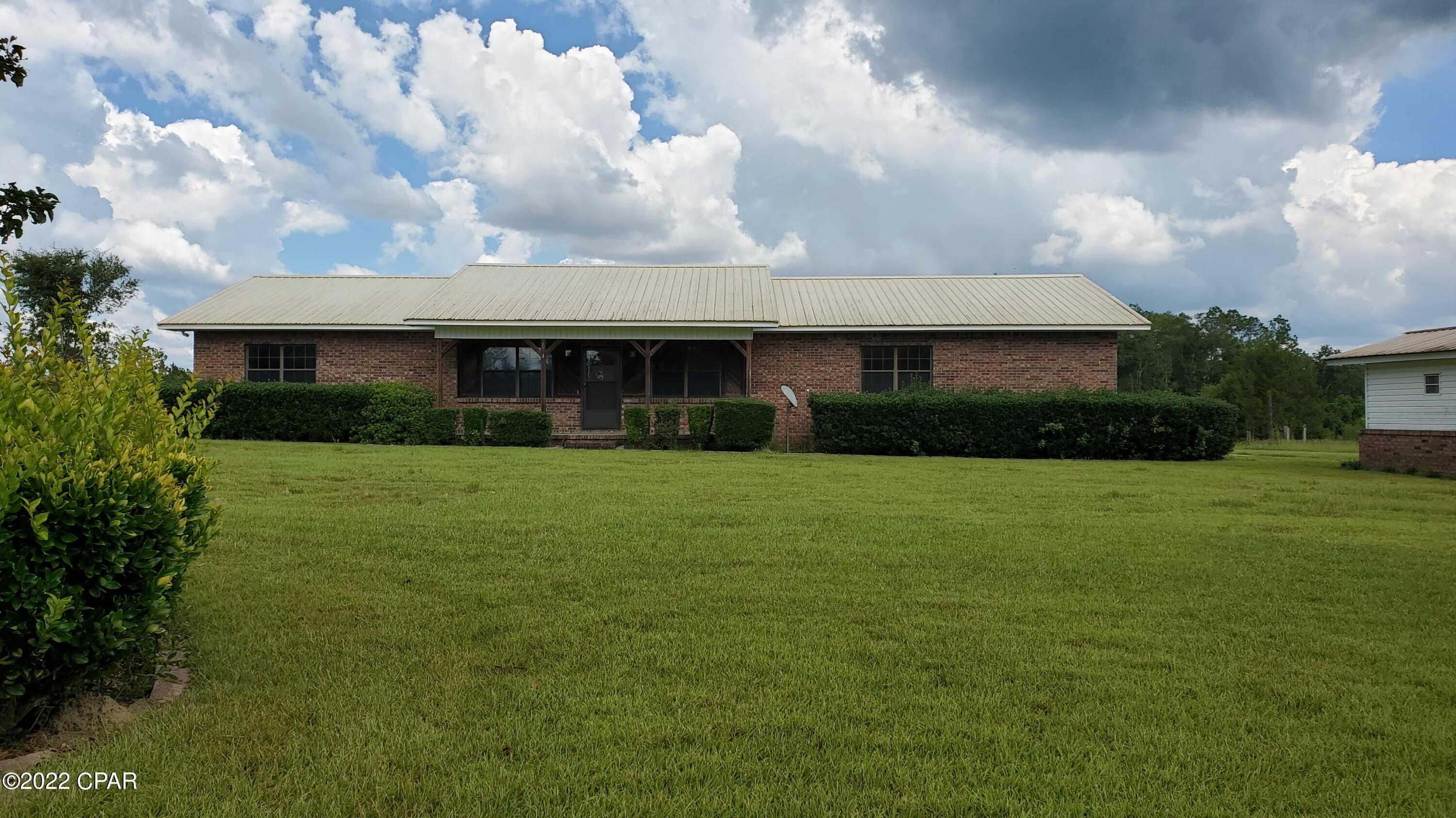 'CURRENTLY UNDER CONTRACT, SELLER WILL CONSIDER BACKUP OFFERS - 3/2 Country Home and 40 Acres of land with  crop land, woods and a natural pond! Enjoy the cool nights on your screened porch and patio. There's a Large Stone Fireplace to keep you cozy in the winter. This Split Floor Plan has a Master Bedroom with a large bath and walk in closet. Attached to the Master is Office/Study with separate entrance from double garage.  Property had recent storm damage with extensive to the buildings and  Minimal damage to the home.  Priced with allowance of loss of buildings.  Call for details and check out this great investment. Bedroom is an office or study with its own private entrance. There are no restrictions on this property.  With easy access to Highway 231 and Interstate 10, you'll have a straight drive of about 60 miles to Panama City Beach!  Located in the Panhandle of Florida where we have the best of all - rural communities, close to colleges, hospitals, larger cities and the world's most beautiful beaches.