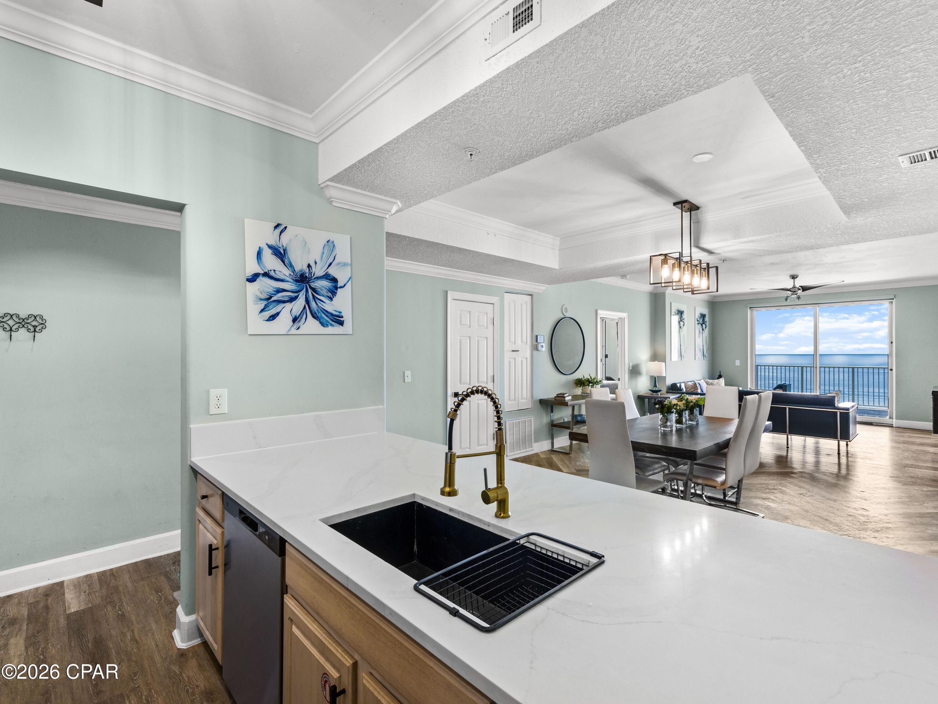 Thirteen floors above the shoreline, the gulf stretches seemingly without end as waves roll toward the beach below and sunsets fill the western horizon. That extraordinary perspective defines this renovated four-bedroom, four-bath residence at Ocean Ritz, where two gulf-front suites and an expansive 300-sq.-ft. balcony place the water at the center of the experience. Generous interiors, thoughtful updates and an established rental history add substance to the setting, creating a coastal retreat equally suited to personal enjoyment and investment.

The open living and dining areas face the water and extend naturally to the oversized gulf-front balcony. With approximately 300 square feet of outdoor living space and seating for eight, the balcony offers ample room for dining, entertaining or simply taking in the shoreline and the sound of the waves below. Its mid-building elevation rises above much of the surrounding street noise while maintaining a close connection to the gulf.

Luxury vinyl plank flooring runs throughout the residence, creating a cohesive look from room to room. The updated kitchen features quartz countertops, stainless steel appliances, a spacious island with bar seating and an open configuration that keeps the kitchen connected to the main gathering areas. An adjacent dining area comfortably seats eight, providing plenty of space for meals and entertaining.

Two gulf-front king suites are among the residence's most distinctive features, each offering panoramic water views and an ensuite bath. Two additional bedrooms each include a queen bed and twin bunks, creating flexible sleeping arrangements for family and guests. Four full bathrooms further enhance the functionality of the floor plan, while an in-unit washer and dryer add everyday convenience.

Offered fully furnished, the residence is well positioned for use as a second home, investment property or a combination of both. Its established short-term rental performance includes more than $112,000 in gross rental revenue in 2025. Year-to-date rental revenue is approximately $100,000, with current projections placing full-year gross revenue at approximately $115,000.

Ocean Ritz provides direct beach access, plus a heated community pool, hot tub, sauna, and grilling area. Restaurants and shops are within walking distance, while Shipwreck Island Waterpark, Pier Park and a wide range of Panama City Beach dining, shopping and entertainment are nearby. With four bedrooms, four baths, two gulf-front suites, an exceptionally large balcony and a proven rental history, this updated residence offers a compelling opportunity along the Gulf of Mexico.
