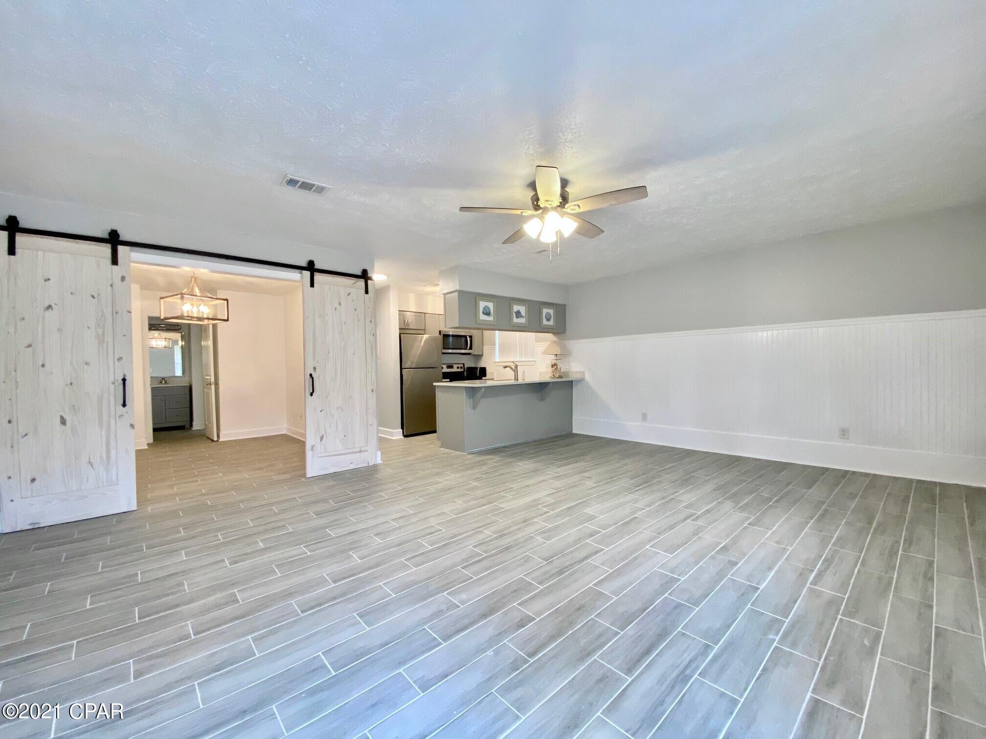 CURRENTLY UNDER CONTRACT, SELLER ACCEPTING BACKUP OFFERS - Fantastic ground floor Greenwood Estates 2-bedroom,1 bath condo! Great Panama City Beach location for a very affordable beach getaway condo or permanent home! Why rent when you can own for less? Completely renovated with a Coastal charm and feel. NEW drywall & paint! NEW ceramic tile flooring! NEW trim, baseboards, doors and even a barn door! NEW kitchen cabinets, granite counter tops, and stainless-steel appliances. Unit 4-D is right across from the pool and Grand Lagoon is just steps away. This Unit does not come with a boat slip but can be purchased from an owner or the HOA when one becomes available. Greenwood Estates is a charming complex with no short-term rentals and is convenient to shopping, dining, and more!