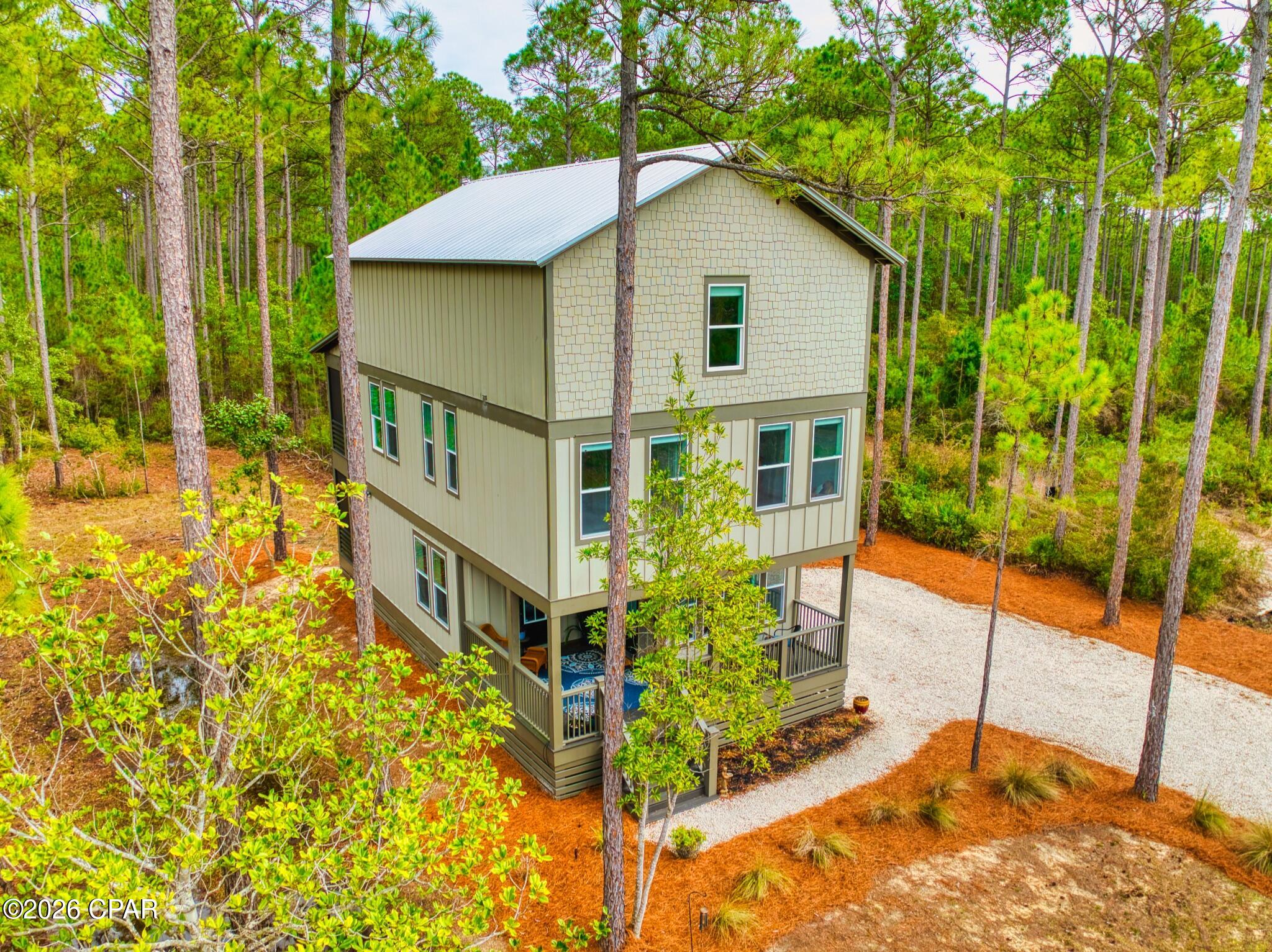 Welcome to 7537 Shady Glen Trail. Sitting on 0.62 acres, this 3 level home is ideal for a primary residence or second home with plenty of space to entertain. RiverCamps on Crooked Creek is located on the west end earning itself the title of Panama City Beach's hidden wooden oasis. The development sits on 1,500 acres, two thirds of that being devoted to conservation. The community has a zero-entry pool, approximately seven miles of interconnecting trails and boardwalks, boat launch and trailer storage, playground, pickle ball courts, designated campground space, NEW west-end mailboxes, and the future fitness center is projected to open this Fall! 

Situated on the first floor is the main living space with a half bath and kitchen, equipped with LG electric range and KitchenAid refrigerator and dishwasher. Step through the sliding glass doors onto the screened in porch with an additional fridge, perfect for morning coffee and dinner parties. The second floor hosts the primary bedroom with direct access to a screened-in balcony, spacious bathroom with plenty of storage, and walk-in closet. There are two other bedrooms on this level with opportunities to turn them into a home gym or office. Conveniently located between the main bedrooms is the laundry area (LG WashTower Stacked Laundry Center). The third level has a second living area, full bathroom, and secondary primary bedroom. Within the bedroom is a hidden storage area with a door disguised as a bookcase for easy access to additional storage.

RiverCamps is nestled on the north side of West Bay conveniently located: 10 miles from the beach; less than 15 minutes to NW Florida Beaches International Airport (ECP); FSU/TMH Medical Campus; Watersound West Bay Center along 79 (Publix projected to open in 2026); 45 minute boat ride to Shell Island; future Point South Marina West Bay.