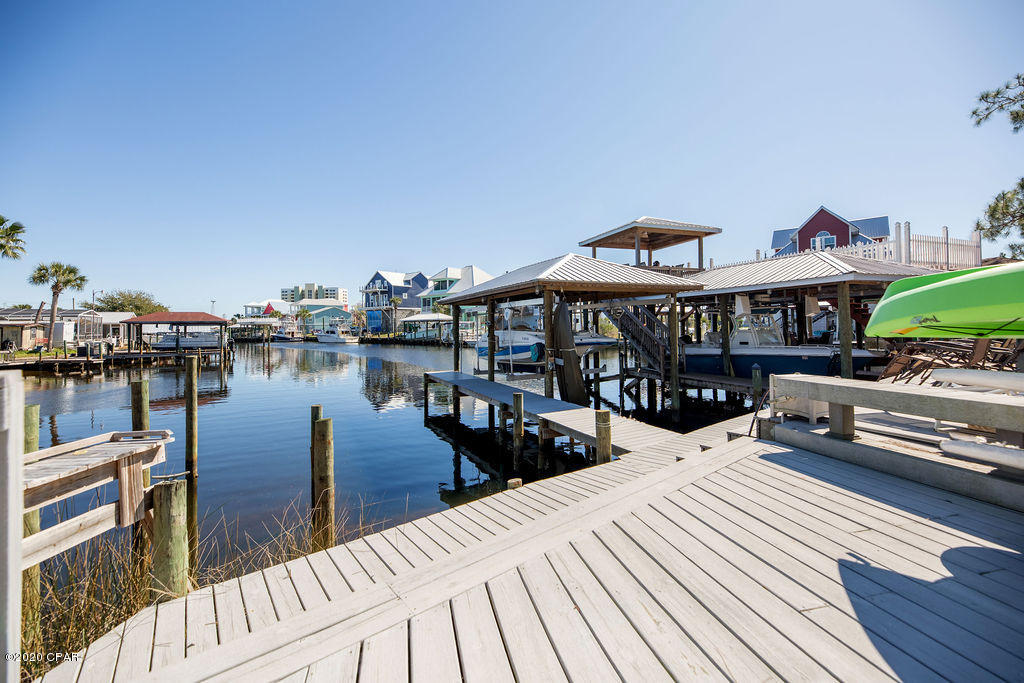 Back on the Market after some owner and neighborhood upgrades!! Bring your boat of any size and be on the big water in minutes from this beautifully upgraded townhome in the gated community of Harbour Towne! This 2 bed, 2 and a half bath, townhouse has been upgraded inside and out with vinyl siding, metal roof, and an amazing extended deck overlooking the water for warm summer night entertaining. Finish the dock or just tie off on new pylons and bring your boat in 20 feet of deep water frontage. Fresh paint on back deck and front porch as well as additional landscaping. The neighborhood has just resurfaced all the roads and parking areas too! The inside of this home has been completely upgraded with vinyl plank flooring, crown molding, farm sink, quartz countertops, tankless water heater, security system, stainless appliances, enclosed upstairs balcony, high end furnishings... you've got to see for yourself, there's too much to list! Make your showing appointment today to see this fantastic home!!