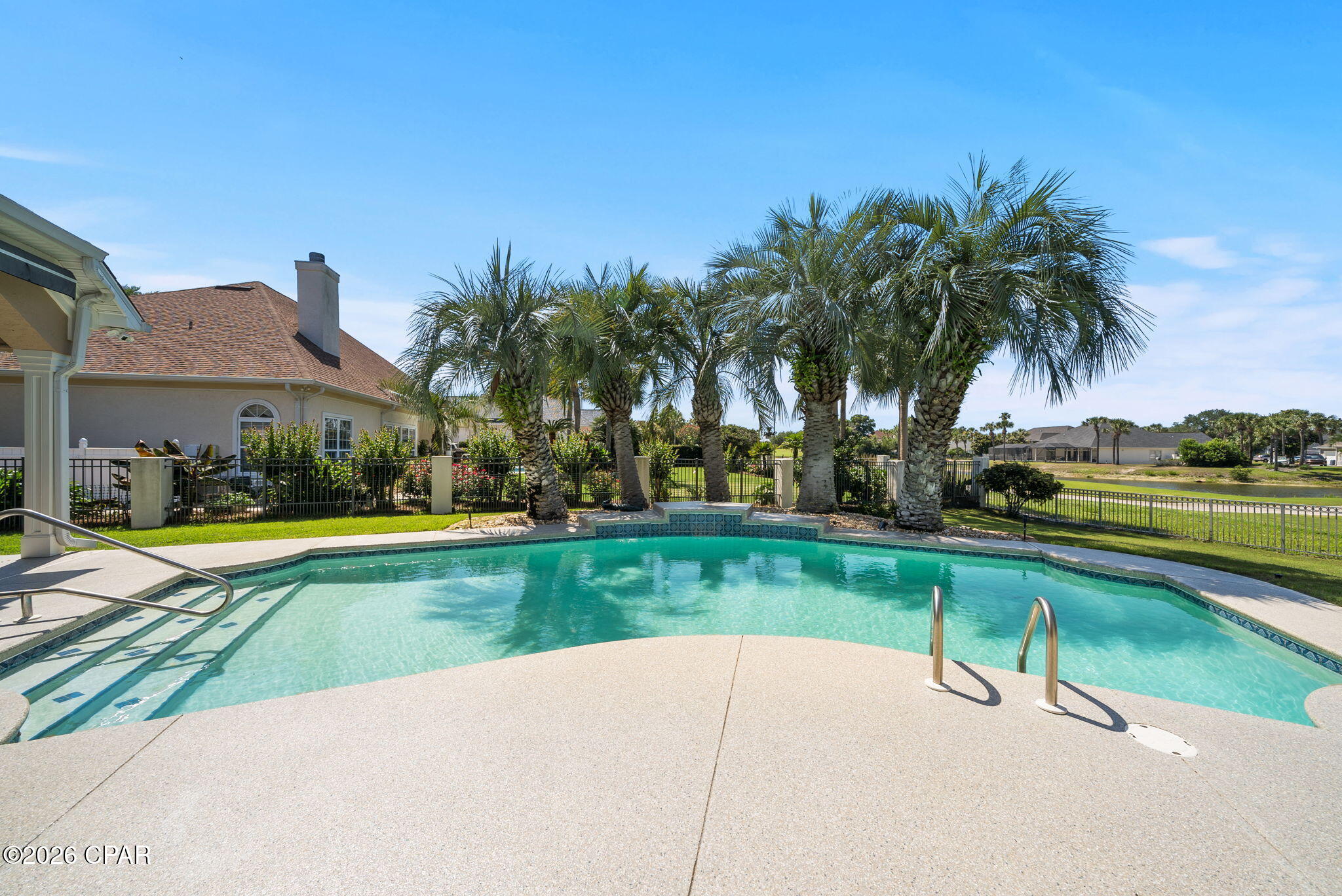 Wake up to pristine fairway views, spend your morning on the only Nicklaus Design Course in Northwest Florida, and your evening toasting the sunset on the sugar white sands of the Gulf.  This isn't a vacation, its your everyday life.  Situated directly between the 10th green and 11th tee box of the Legends golf course, this pristine 3,055-square-foot estate in Bay Point's prestigious Queensberry neighborhood redefines daily living minutes from Gulf beaches and St. Andrews State Park. The outdoor sanctuary centers around a heated in-ground pool with a tranquil waterfall (resurfaced in 2024), framed by professional landscaping and 2023 exterior lighting. Spend your afternoons relaxing poolside, taking in fairway views, or watching deer graze on the green at dawn. Inside, an expansive circular driveway leads into light-filled living spaces marked by soaring 14-foot ceilings, high-end crown molding, built-in bookcases, and a gas fireplace. Work comfortably from a private home office overlooking the course, or make use of a versatile laundry suite that transitions into a home gym or craft room. Recent interior updates include fresh paint and a newly renovated primary bathroom (2025). The kitchen serves as the heart of the residence, featuring a farmhouse sink, gas stove, custom cabinetry with pull-out organizers, and premium appliances upgraded between 2022 and 2024. Modern conveniences like power window shades, a central vacuum system, floor-integrated outlets, and a specialized front-porch timer for seasonal lighting make day-to-day operation seamless. Every mechanical and structural detail has been well maintained, including dual HVAC units (one replaced in 2022), a three-car garage with generous storage, and full exterior protection via hurricane fabric and shutters. Tucked away from the city's hustle, this home offers the ultimate retreat--combining the rare privacy, security, and distinction of an established gated community with world-class leisure right outside your front door.