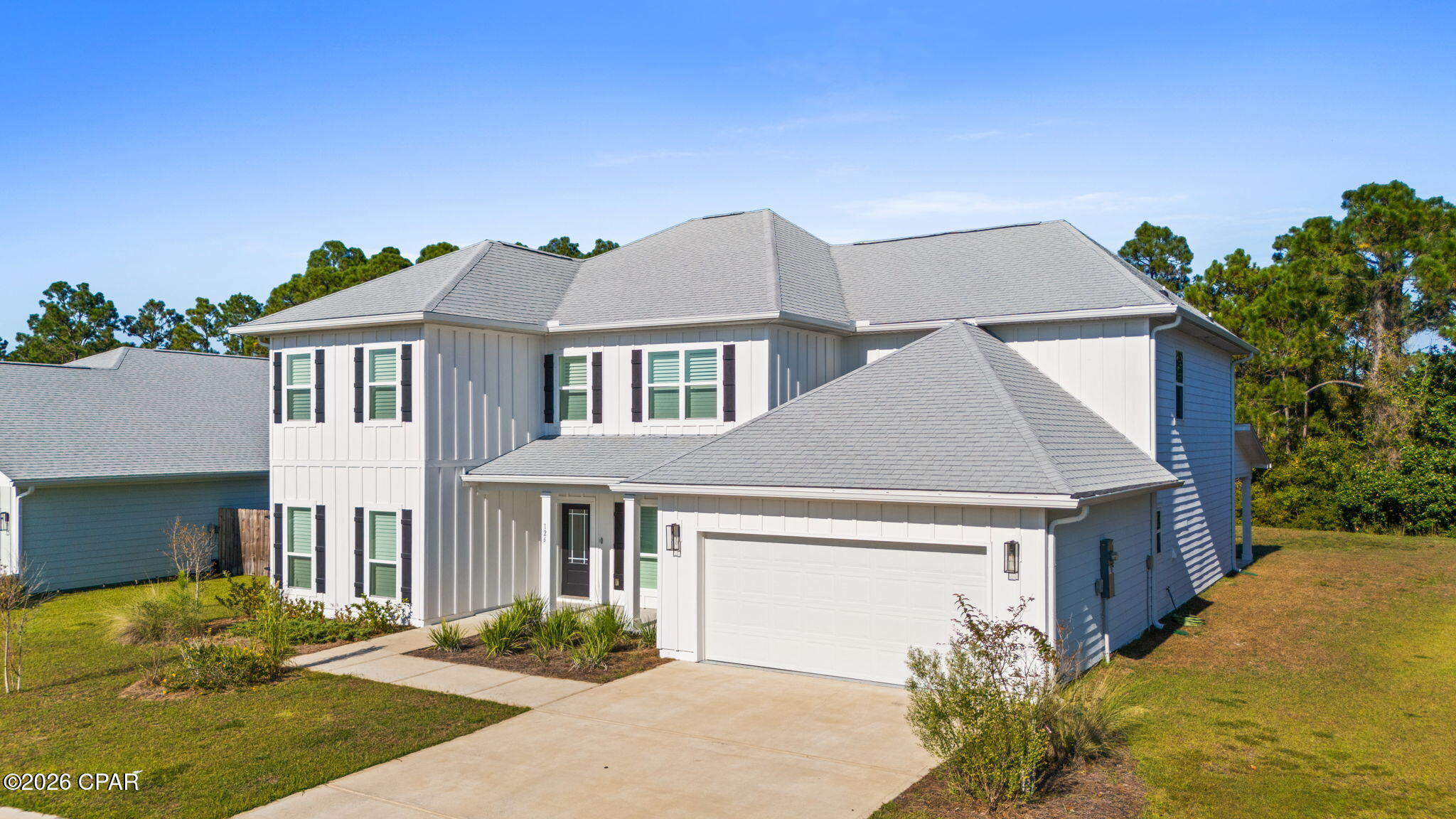 Experience modern coastal living in this stunning 6-bedroom, 4-bath contemporary home in a sought-after new Panama City Beach community. Just 5 minutes from Pier Park and the beach, this spacious retreat features premium flooring, quartz countertops, and abundant natural light. Enjoy plantation shutters throughout, motorized blinds in the great room, and a stylish brick glass mosaic kitchen backsplash. Tile shower walls, tiled front and back patios, and an AquaPro water filtration system add luxury and comfort. The custom-finished garage floor and large quarter-acre lot complete this beautifully upgraded coastal home.