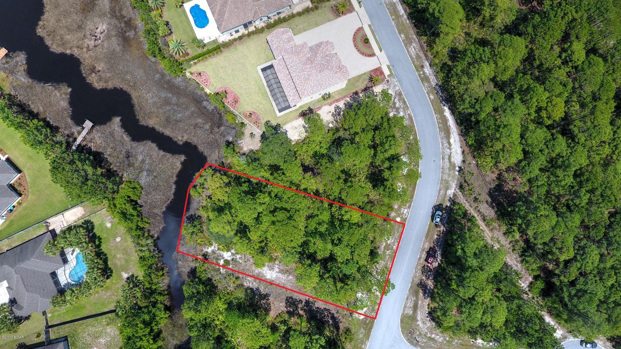CURRENTLY UNDER CONTRACT, SELLER ACCEPTING BACKUP OFFERS. $20,000 Price Reduction...Seller Motivated!  Waterfront home site in the gated community of Trieste. This 100 x 200 (.44 acre) lot would be ideal for building your dream home. It's situated on a canal which leads to St. Andrews Bay. You can launch your kayak or John boat right behind your home! And what a wonderful place to call home with easy access to the Holiday Golf Course just around the corner and the beginning of Gayle's Trails located just outside the gates of the neighborhood. You're also just minutes to Pier Park! This exclusive neighborhood is filled with Mediterranean style homes.  Isn't it time to add your own?  All info is approx. and must be verified by Buyers if important.
