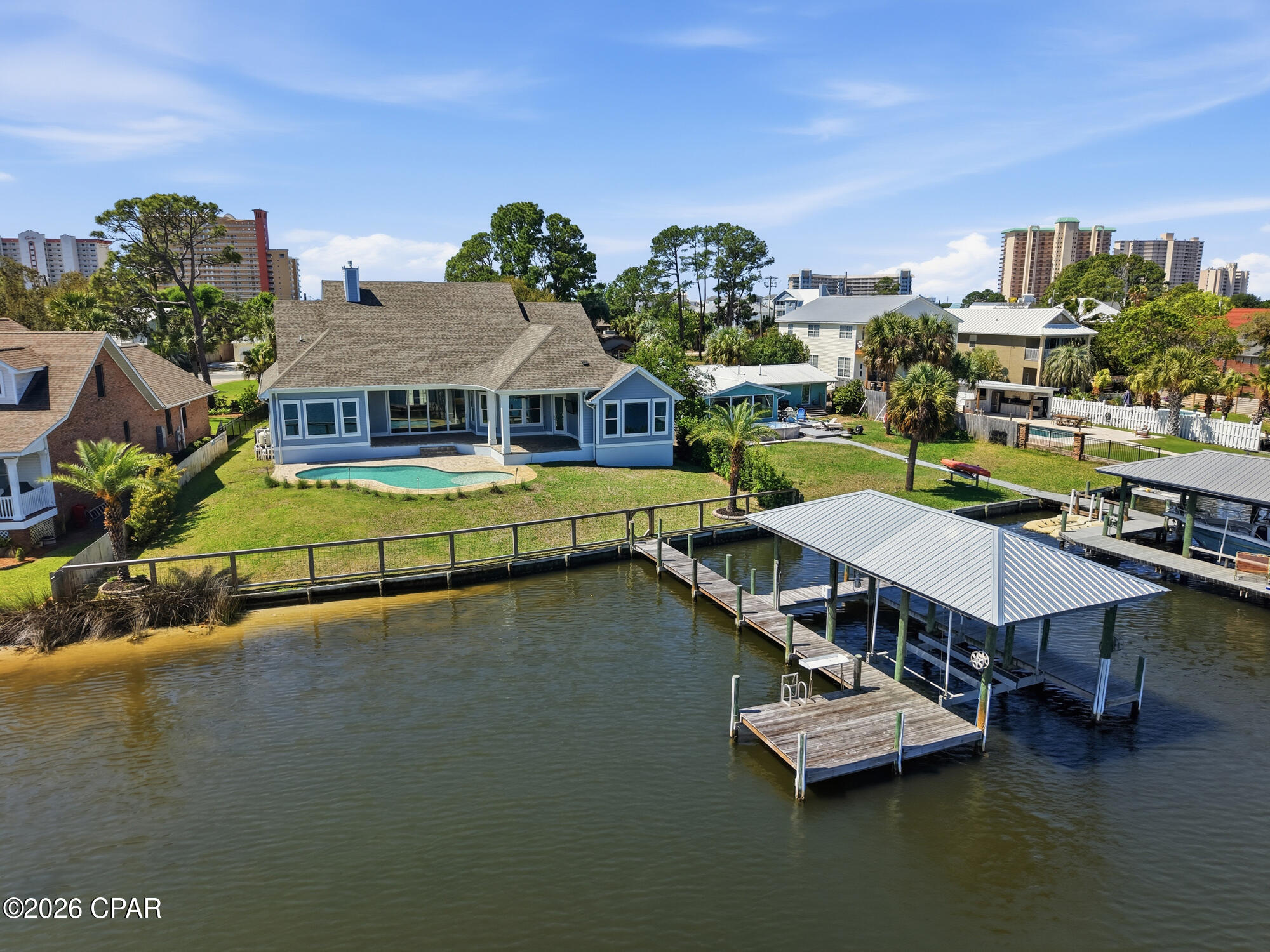 CURRENTLY UNDER CONTRACT, SELLER WILL CONSIDER BACKUP OFFERS
Welcome to 6728 South Lagoon Drive, a stunning waterfront retreat perfectly positioned on South Lagoon in Panama City Beach. Built in 2020 by Arthur Rutenberg, this exceptional one-story residence offers 3,404 square feet of heated and cooled living space and 4,938 square feet under roof including the outdoor living areas. An upgraded version of the sought-after May River floor plan, this home sits on a rare double lot and showcases quality craftsmanship, thoughtful design, and luxurious coastal living at its finest.

This boater's paradise offers unobstructed water views and seamless indoor-outdoor living designed to capture the beauty of the lagoon. The spacious 4-bedroom, 3-bathroom home features an open-concept layout with breathtaking views from the kitchen, dining, and living areas. The expansive living room is highlighted by vaulted ceilings, a cozy gas fireplace, and floor-to-ceiling glass sliders that open completely to a covered outdoor living space--perfect for entertaining or relaxing while overlooking the water. The dining area is filled with natural light from elegant bay windows, and the kitchen is thoughtfully equipped with a gas stove, a double oven, two refrigerators, and a generous walk-in pantry. Beautiful hardwood floors run throughout the main living spaces, while quartz countertops are featured throughout the home, with granite in the laundry room for added durability.

The primary suite is a true private retreat, featuring a split floor plan with double doors that allow you to close off the bedroom, closets, and bathroom from the rest of the home for maximum privacy. The suite also includes his and hers walk-in closets, offering ample storage and organization. The spa-like primary bathroom includes a standalone soaking tub, a marble, zero-threshold (curbless) oversized dual shower head shower, and a his-and-hers vanity--complete with a dedicated sit-down makeup area on the hers side for added luxury and convenience. The suite is also framed for a private exterior door, offering even more flexibility.

A versatile multi-use office with beautiful beamed ceilings adds character and flexibility for work or additional living space.

Step outside to your private oasis featuring a 6-foot inground saltwater pool complete with bubblers and a sun shelf. The fully fenced yard includes a sprinkler system powered by a separate well, a gated and paved driveway, and a 3-car garage with an elevated lift for easily accessible extra storage. The home is also equipped with gutters, spray foam insulation for energy efficiency, a tankless hot water heater, and a built-in monitored security system with hardwired outdoor cameras for added peace of mind. An in-wall pest control system further enhances convenience.

For boating enthusiasts, this property truly stands out with a covered boat lift, deep water dock, and seawall--allowing you to take your boat out anytime of day regardless of the tides. Enjoy a quick 15-minute boat ride to the open Gulf or take a short 5-minute drive to the area's famous white sandy beaches. Pier Park is just 20 minutes away, offering shopping, dining, and entertainment. Located in a golf cart-friendly community, this home offers both convenience and a relaxed coastal lifestyle.

With gas and electric already available for an outdoor kitchen, this home is ready to create the ultimate waterfront experience.

Don't miss your chance to own this exceptional coastal property where luxury, comfort, and breathtaking views come together.