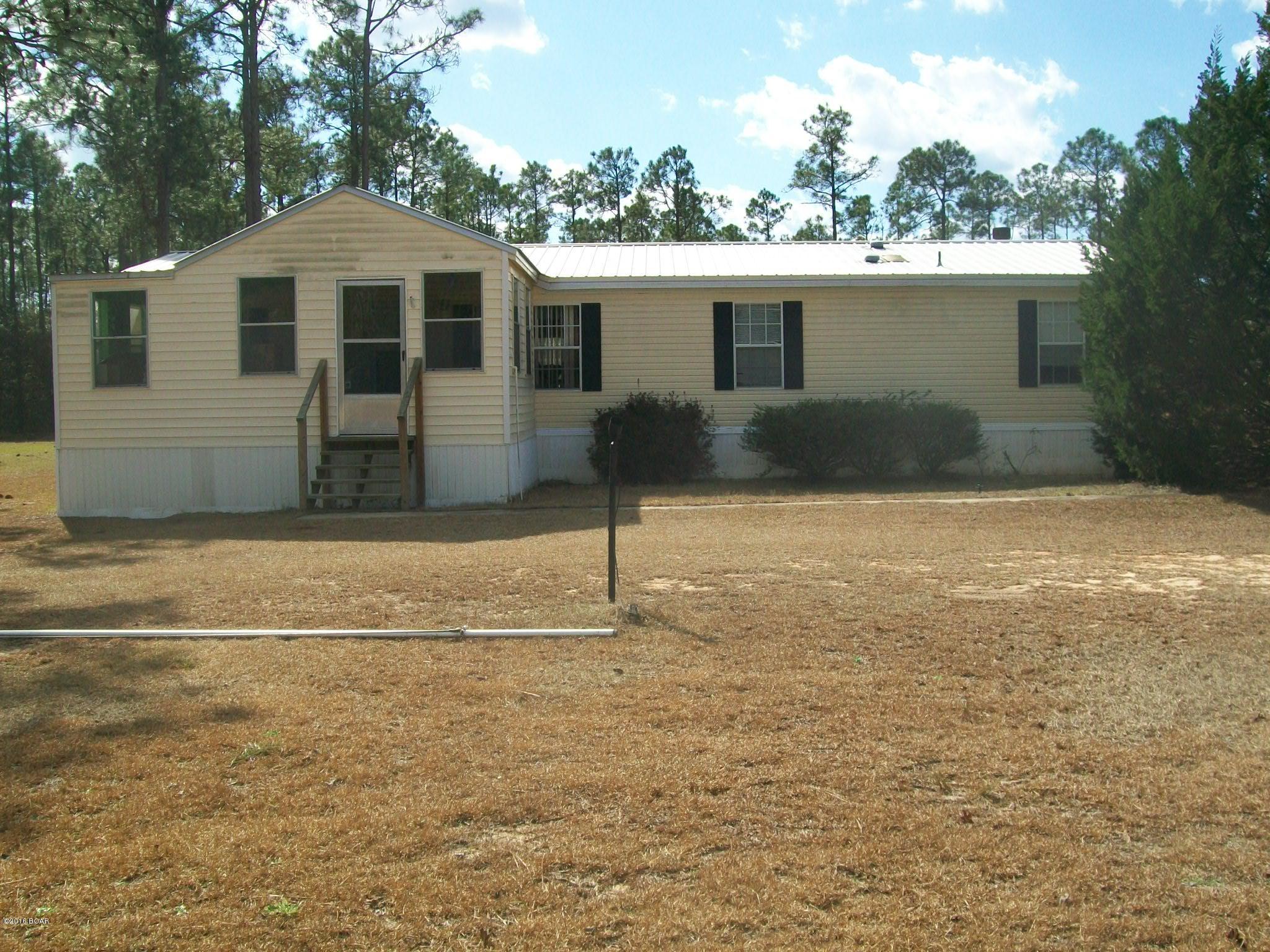 Has Block workshop with walk thru door and roll up garage door with additional storage on back of shop