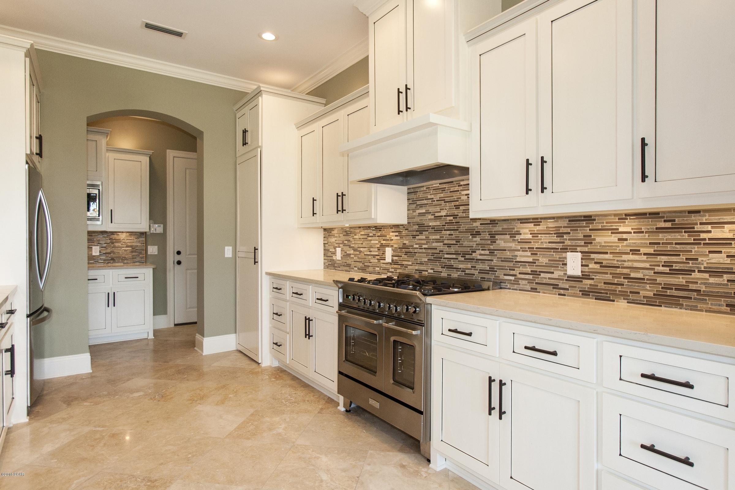 Designed by Dryden Contracting Inc., this firm brings their luxury home style to Bay Point and the surrounding areas.  This gorgeous Tuscany inspired home features many unique features that comes from years of building exclusively custom homes.  A few items to be included in this home, Crown Molding throughout main living area, hardwood flooring, Quartz counter tops, premium appliance package, custom cabinets, 10ft ceilings and much more...Furthermore this will all be topped off with a custom landscape plan.  Make an offer early and choose your finishes or design your home today with their state of the art design team. Additional amenities for this home:

1st floor features 10',11' & 21' ceilings 
Natural Gas commercial Range with high CFM vent hood
Gourmet Kitchen
Custom Cabinet Pantry
Outdoor Stone Summer Kitchen w Natural Gas Grill
High Impact Hurricane Windows everywhere
Extra tall garage doors 9'x9'
Solid Hammered Copper Master Tub
Master Shower features 2 rain heads, hand shower and 3 body jets
Separate Custom Feature Bathroom Prep Vanity
Master and Guest Suite on First Floor
2 bedrooms plus 12' ceiling Flex / Rec Room on Second Floor
Huge Rear Decks on 1st & 2nd overlooking Grand Lagoon
Spray Foam insulation with 2x6 exterior walls engineered beyond FL code requirements for Wind
Lush Landscape package including many Palms surrounding the property.