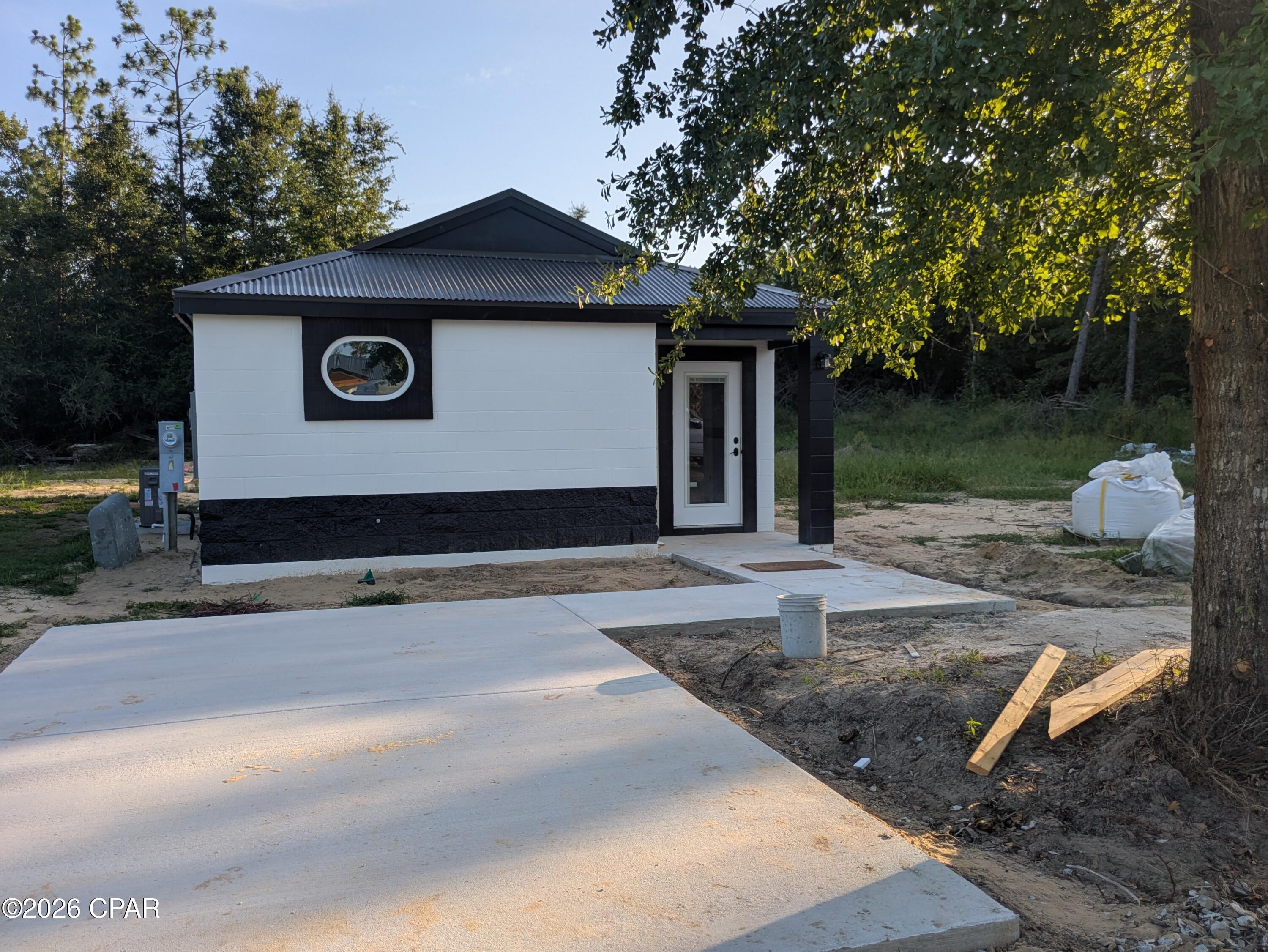 This home is almost finished! If you like quiet country living, sturdy construction, and low cost living, you need to check out this brand new home to be completed in 2026. Modern open concept living area with unique bedroom plan, new appliances, and stylish finished concrete floors, formica countertops, concrete driveway, and a covered front porch. With sturdy concrete block construction, metal roof, high efficiency HVAC System, private well, and new septic system you'll enjoy low maintenance and low utilities. No HOA. Located in a quiet area north of Panama City convenient to Hwy 231 and Hwy 20. Only 30 minutes to Panama City, 40 minutes to Panama City Beach. Minutes away from Youngstown Recreational Park & Pitt & Sylvan Springs Park. See Floorplan in photos section. Completed home photos are of similar construction and finishes. Additional homes being built, contact us for more information!