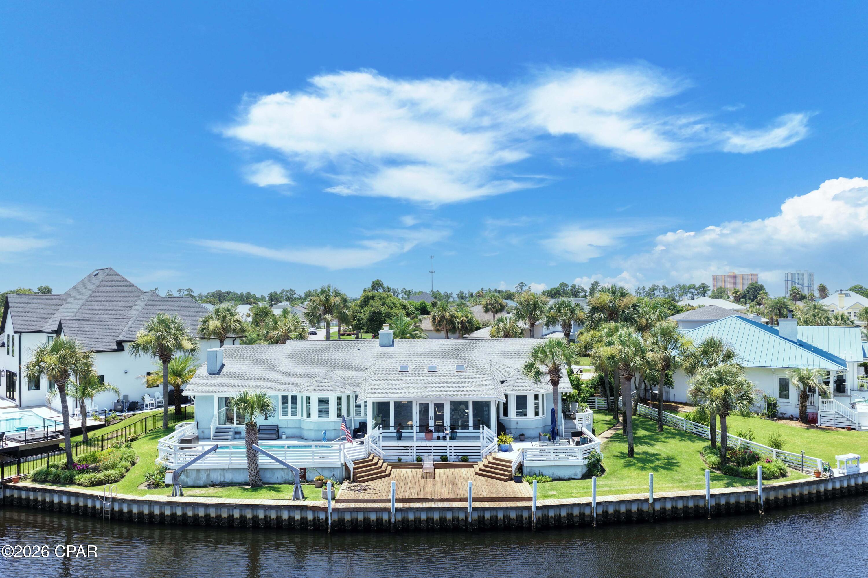 Welcome to the coastal life!  Come experience some of the best waterfront views in all of Bay Point! Situated on a premier waterfront homesite with approximately 149 feet on one of the widest sections of the canal, this beautiful property offers panoramic water views.  This is the perfect setting for the ultimate coastal lifestyle, where you can keep your boat at your backdoor and be ready to go fishing and boating at a moment's notice.  Enjoy the large waterfront deck and sparkling pool, where you'll spend countless hours relaxing, entertaining, and taking in the incredible canal views.  This spacious home features over 3,300 square feet, 3 bedrooms, and 3 full baths all on one level for easy living.  The expansive primary suite is a private waterfront retreat with a sitting area, oversized walk-in closet, and en-suite bath. Each of the two additional bedrooms offers its own private bath, providing comfort and privacy for family and guests. The open-concept floor plan is ideal for entertaining, featuring views from literally almost everywhere, tons of natural light, generous living spaces and entertainment spaces as well as a built-in bar, making this home perfect for hosting and enjoying family and friends.  Located within the prestigious gated community of Bay Point, residents enjoy world-class amenities including the Jack Nicklaus Championship Golf Course, a full-service marina, on-site restaurant and bar, and 24-hour gated security. You are ideally located and convenient to St Andrew's State Park, white sandy beaches, grocery, shops and restaurants and more.  This is a rare opportunity to own a home on a premier waterfront homesite in Bay Point.  Call today and make this your next home!
