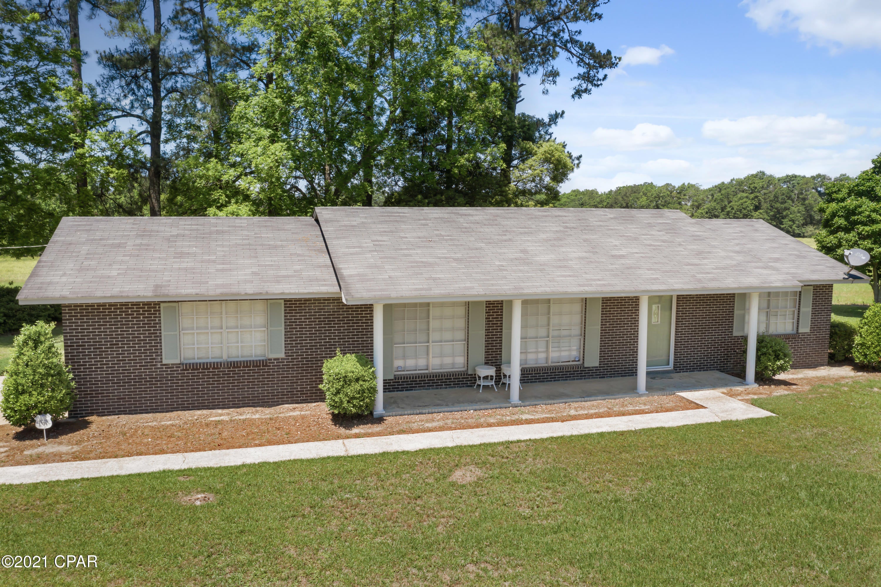 CURRENTLY UNDER CONTRACT, SELLER WILL ACCEPT BACK UP OFFERS. Well maintained 2/1.5 brick home on 57.11 +/- acres. Home offers a open kitchen with lots of storage, breakfast bar, and dining area. Spacious living room. Large windows allow for natural lighting. One bedroom has half bath with additional closet space in hall. Additional bedroom and full hall bath with tub/shower. Sit outside on the covered front porch or 36x14 covered patio area. Pond has bass and brim. Plenty of room for pasture,  or crops. Partially fenced. Home has newer roof, well, and central heating and cooling. Easy access to Hwy 79 to visit Panama City Beach and Hwy 2 for access to other areas close by. Come and enjoy the peaceful country living.