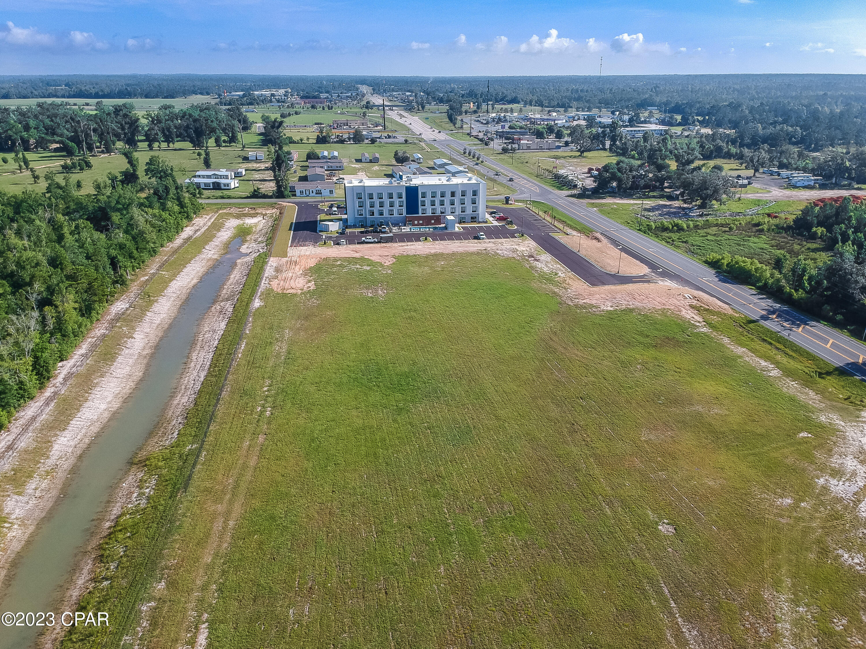 2 CLEARED and PAD READY Prime Commercial Lots for a total of 12.17 acres, which includes stormwater in place and water/sewer lines that run on both HWY 71 and Hope School Rd., and natural gas is available.  All utilities, including regional stormwater, are in place with common use driveways permitted and recently completed for access from both Hwy 71 and Magnolia Rd. The Magnolia Rd driveway entrance and the North Hwy 71 driveway entrance have both been completed and are now in use. The South Hwy 71 driveway entrance is permitted and ready for construction.  There is a 40-unit townhome project in the southwest corner of Hope School Rd, which is currently under review by the county and a development order in the works. There is also a newly constructed 4-story Hampton inn, adjoining to the north, that opened in May 2023, and 1500 feet from the new Chick-Fil-A that opened in April 2023. This parcel is less than a minute to I-10, which has well over 20,000 vehicles per day traffic count, and in the heart of Marianna, surrounded by big projects, and yours could be next!  This parcel totals 12.17 acres with approximately 2.5 acres of stormwater, leaving approximately 9.67 acres of 90% impervious development potential.  There are so many opportunities with this large parcel, and the hard work has been done for you.  There is an HOA, and documents are attached to the listing, but fees are not in place at this time. The HOA will transfer with the sale if the buyer would like.  An agreement is in place for shared drainage and easement maintenance based on pro-rated ownership with the hotel and town home community.  The seller has conceptual drawings for a strip center, and QSR restaurant as well as site drawings, original 14 acre survey (included hotel/townhome...not included in this sale), original topo survey elevations, HOA agreement, site plans for this lot, as well as the hotel and townhome parcel, original set of approved stormwater, driveways and utility plans, , and even a phase I environment report (dated 2006), which they are willing to share with a serious buyer with a signed NDA agreement. This area is home to many commercial businesses with a diverse range of industries and makes an ideal location for any new business and ready for your creative touch. If this sounds like the property you have been waiting for, make an appointment to view today before this prime commercial property is no longer available. All information is deemed reliable but must be verified by buyer via personal or formal inspections.
