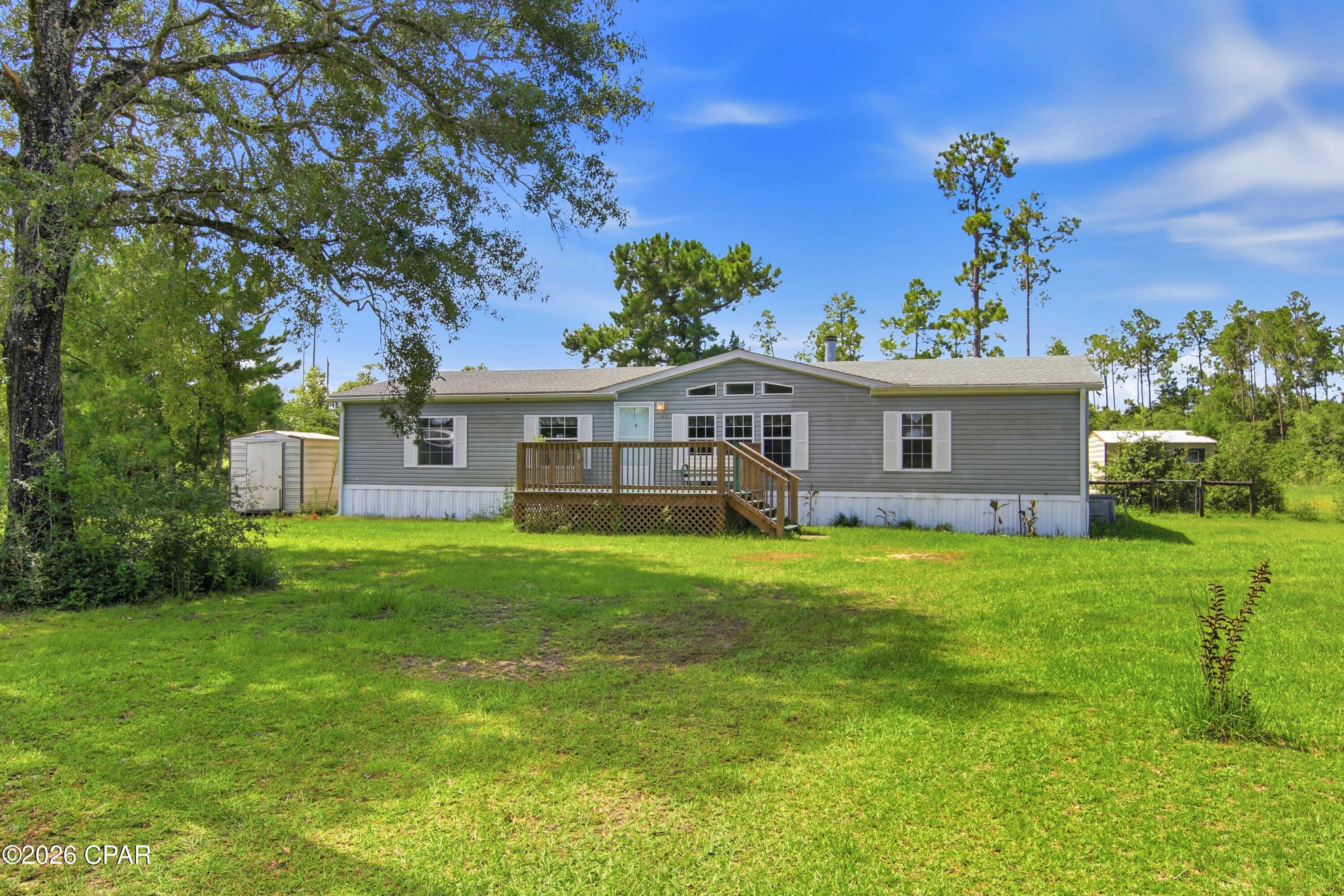 Country Living on 5 Beautiful Acres!

Escape to the peace and privacy of rural Bay County with this spacious 3-bedroom, 2-bath mobile home situated on 5 acres full of possibility in Fountain. Offering nearly 2,000 square feet of living space, this home features a comfortable, functional floor plan with generous living areas designed for everyday living and entertaining.

The inviting living room offers plenty of space to gather, while the kitchen provides abundant cabinet and countertop space with an adjoining dining area perfect for family meals. A split-bedroom layout offers added privacy, and the spacious primary suite serves as a relaxing retreat. The primary closet features custom built-in fixtures. 

Step outside and enjoy all the possibilities that come with five acres of open space. Whether you're dreaming of a hobby farm, gardening, recreational vehicles, or simply enjoying the outdoors, this property offers room to make it your own. A pole barn provides excellent storage for equipment, boats, RVs, or tractors, while three storage sheds offer additional space for tools, lawn equipment, and hobbies. Enjoy the spacious front and back deck. Tractor does not convey.

If you're looking for the freedom of country living, this property is just a short drive from Panama City, Marianna or Chipley. while offering the privacy, space, and tranquility you've been searching for. Schedule your private showing today and discover the possibilities this beautiful acreage has to offer!