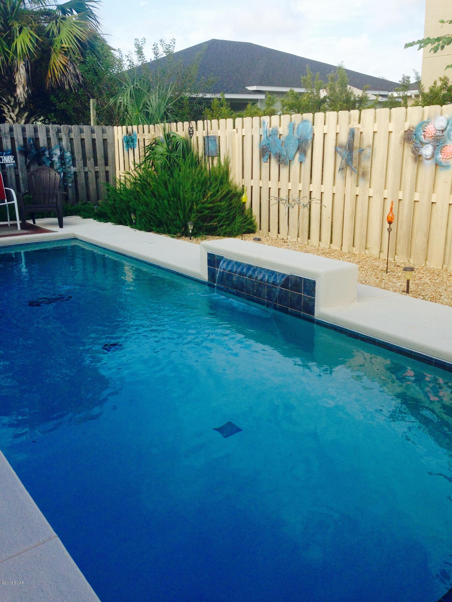 Motivated! Florida Cottage Style near Pier Park with Pool is deceiving..Open the door for pleasant surprise!!! A whole lotta house and cute as can be!!! Just a short walk to the beach!!! This 4 Bedrooms, 3 living areas, 3 bath home makes a great beach house for family or for short term rentals. This concrete block/metal roof construction was built in 1960's but has effective build date of 1980 according to Tax Appraisers office. This home has been enlarged, and has had a great saltwater pool with a waterfall added! Large tile flooring throughout and energy efficient and extremly quiet Mitsubishi heat and air  units as well as Central heat and air. The beautiful and quality furnishings and decor all convey. Home is move in ready!!! 

Large metal storage building/workshop and lots of parking