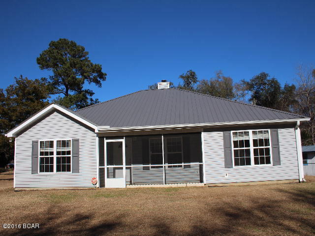 ** PRICE REDUCTION ** Like new home in town! You won't have to do anything to this one! Kitchen is fully equipped with stove,side-by-side refrigerator/freezer, dishwasher and microwave. The living room has a fireplace and there is a split bedroom design. The front features a screened in porch. Lot is completey chain link fenced. There is a 2 car carport PLUS a detached workshop/shed that also has a carport.