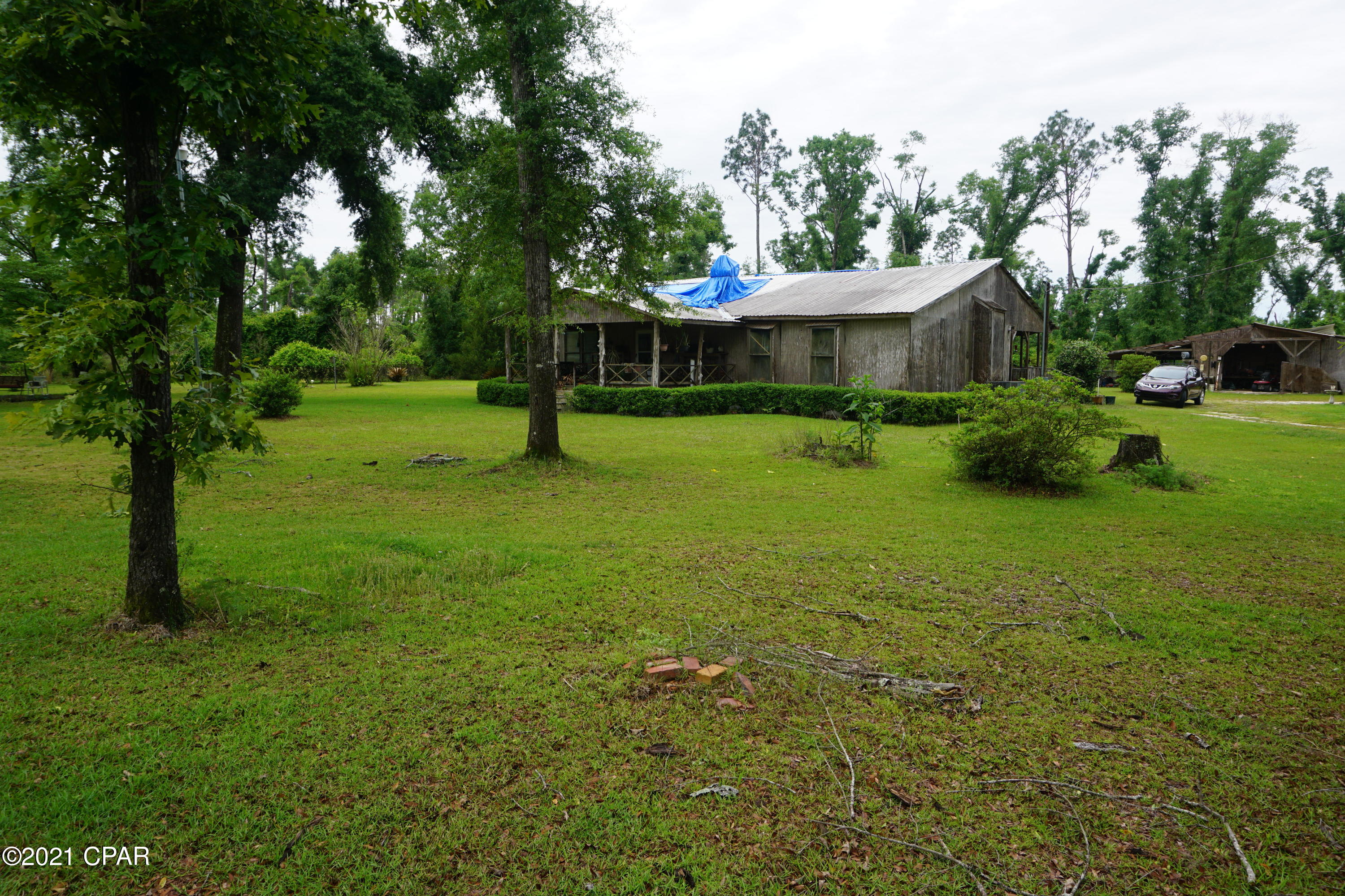 Country living at its best! This acreage offers a small getaway to come home to after a long days work. This home has had some renovations which include a very nice master bedroom, master bath, a large tiled master shower with multiple heads, new kitchen with gorgeous cabinets and wood finishes. The kitchen, dining, and master all have newer laminate flooring. The home needs some roof work to be completed, some sheetrock work on inside ceiling needs repair, crown molding missing, and some other small things. Outside there are two large covered porches on front and the back. Out back there is a large 60'X70' partially closed in pole barn(in need of partial roof repairs) and a smaller 24'X36' pole barn. There is an abundance of wild life with deer constantly walking through the yard.