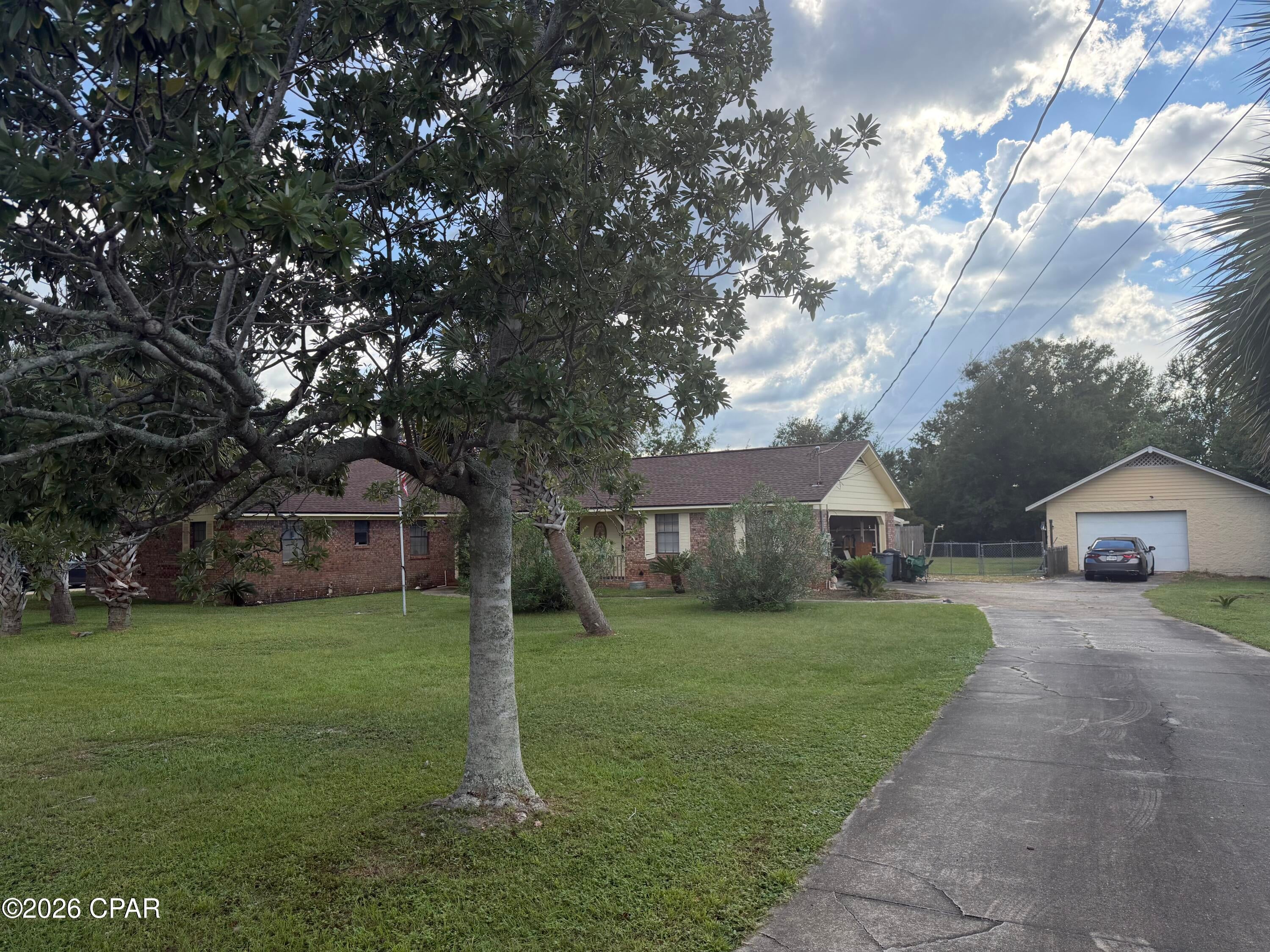 Large family home in need of updates. Located on a dead-end cul-de-sac street situated on a large lot .75 acre with chain link fenced back yard and a concrete block oversized detached garage/workshop. 4 bedroom all brick home with a 2 car attached garage. Enclosed Florida room, which is cooled, just off the kitchen area.