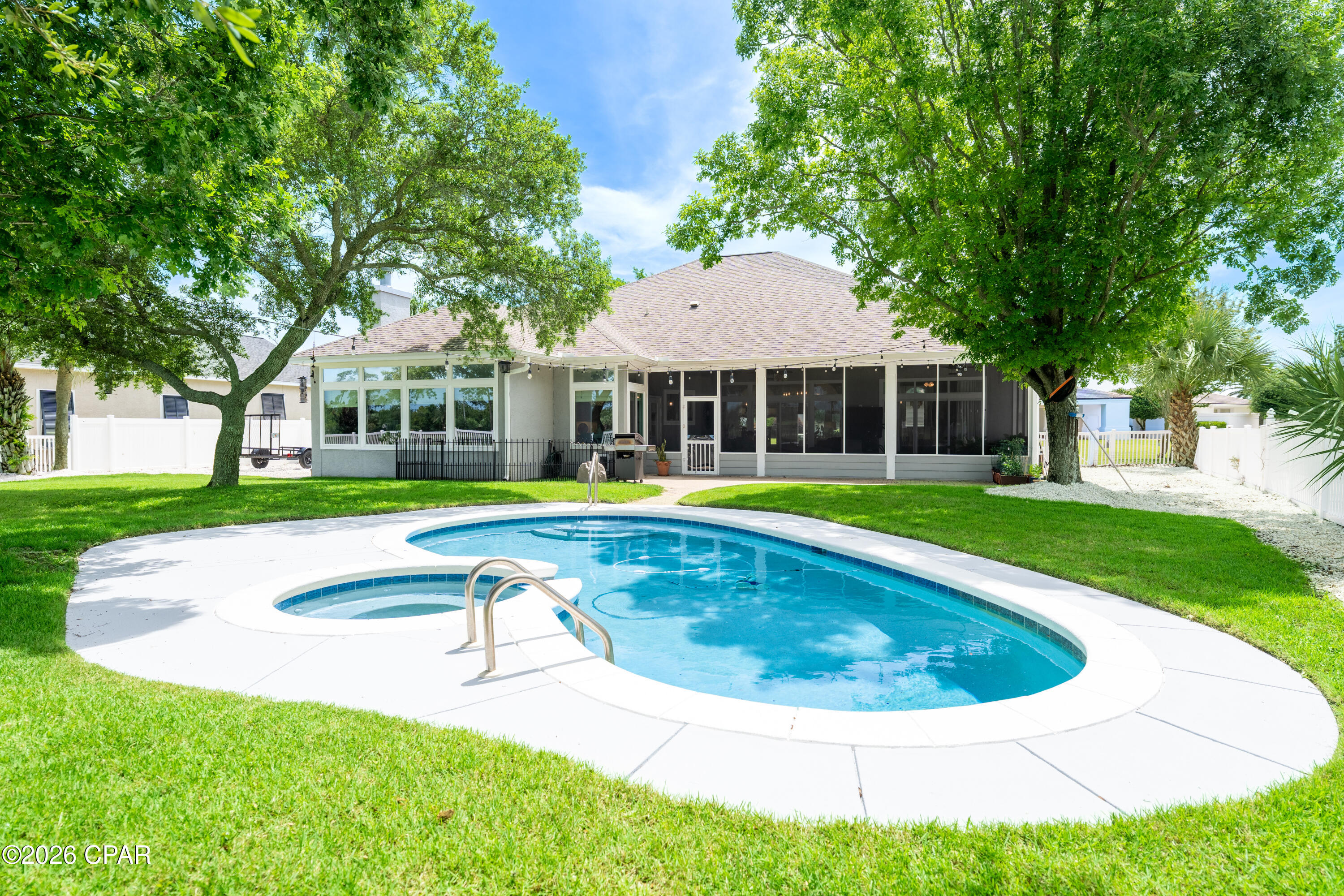 GOLF COURSE LIVING IN BAY POINT'S PREMIER GATED COMMUNITY! Located in the desirable Legend Lake neighborhood and overlooking the Jack Nicklaus Signature Golf Course, this meticulously maintained single-level home offers the perfect blend of comfort, privacy, and resort-style living. Featuring 10-foot ceilings, luxury vinyl plank flooring throughout, and custom shiplap accents, this thoughtfully designed home is ideal for both everyday living and entertaining.
Upon entering, you're welcomed by an elegant front living space with soaring ceilings and expansive windows, offering endless possibilities as a grand piano room, private library, home office, or sophisticated gathering area. The beautifully updated chef's kitchen serves as the heart of the home, featuring custom cabinetry, granite countertops, a spacious center island, farmhouse sink, designer lighting, stainless steel appliances, a separate ice maker, and abundant storage.
Open to the kitchen, the impressive family room showcases dramatic beamed ceilings, a cozy gas fireplace, and a wall of windows framing picturesque views of the private pool and the Jack Nicklaus Signature Golf Course beyond. The large screened porch creates the perfect indoor-outdoor living experience, offering ample space to entertain, relax in the hot tub, and enjoy breathtaking sunsets over the fairway.
The primary suite serves as a private retreat, offering peaceful views of the sparkling pool and backyard oasis, private access to the screened porch, dual walk-in closets, and a spa-inspired bath complete with a soaking tub. Additional highlights include updated bathrooms, custom closets, extensive crown molding, a two-car garage, and double gate access to the fully fenced backyard for storing a boat, trailer, or jet skis.
Step outside to your private backyard retreat featuring a sparkling pool, hot tub, mature landscaping, and panoramic golf course views. Bay Point residents enjoy 24-hour gated security, championship golf, a full-service marina, waterfront dining, walking and biking paths, golf cart-friendly streets, and an active social lifestyle with clubs, events, and live entertainment. Whether you're seeking a primary residence, retirement retreat, or second home, this is a rare opportunity to experience the very best of Bay Point living.