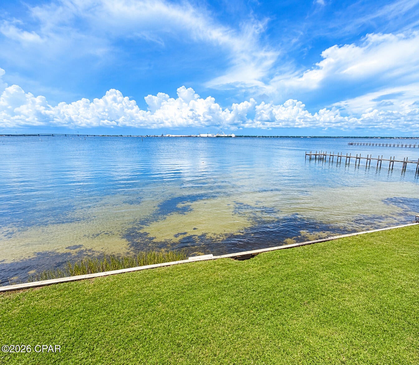 Dreaming of bayfront luxury without the million-dollar price tag? This premium corner end-unit is the one! Offering a rare combination of privacy, space, & sunrises that steal the show, this exceptional townhome features extra side windows that flood the open-concept layout with continuous natural light. Positioned on the largest lot in the community with +/-45 feet of waterfront, it is uniquely bordered by a protected conservation area, giving you unmatched privacy & a peaceful sanctuary where you can watch dolphins, eagles, & deer right from your deck. Nestled in a quiet, non-short-term-rental community zoned for top-rated Patronis Elementary, it is the perfect sanctuary for primary residents, paddle-sport enthusiasts, or those seeking a peaceful waterfront getaway. Enjoy easy waterfront living with a tiled balcony, a screened back porch, a hurricane shutter system, remote blinds, & private bulkhead stairs offering direct water access to launch your kayak or paddle board. This turnkey home is built for peace of mind & low maintenance, featuring a brand-new 2025 upstairs HVAC, a 2024 water heater, new impact family room windows, a 2019 roof, & fresh exterior paint. Located on the quieter end of Panama City Beach, you are just minutes from great dining & shopping. Premium community amenities include two docks, a pool, a hot tub, a clubhouse, & a scenic boardwalk, with lawn care & termite control covered by the HOA. Perfect as a primary residence or second home. Check measurements if important to you. Measurements are from the tax appraiser site.