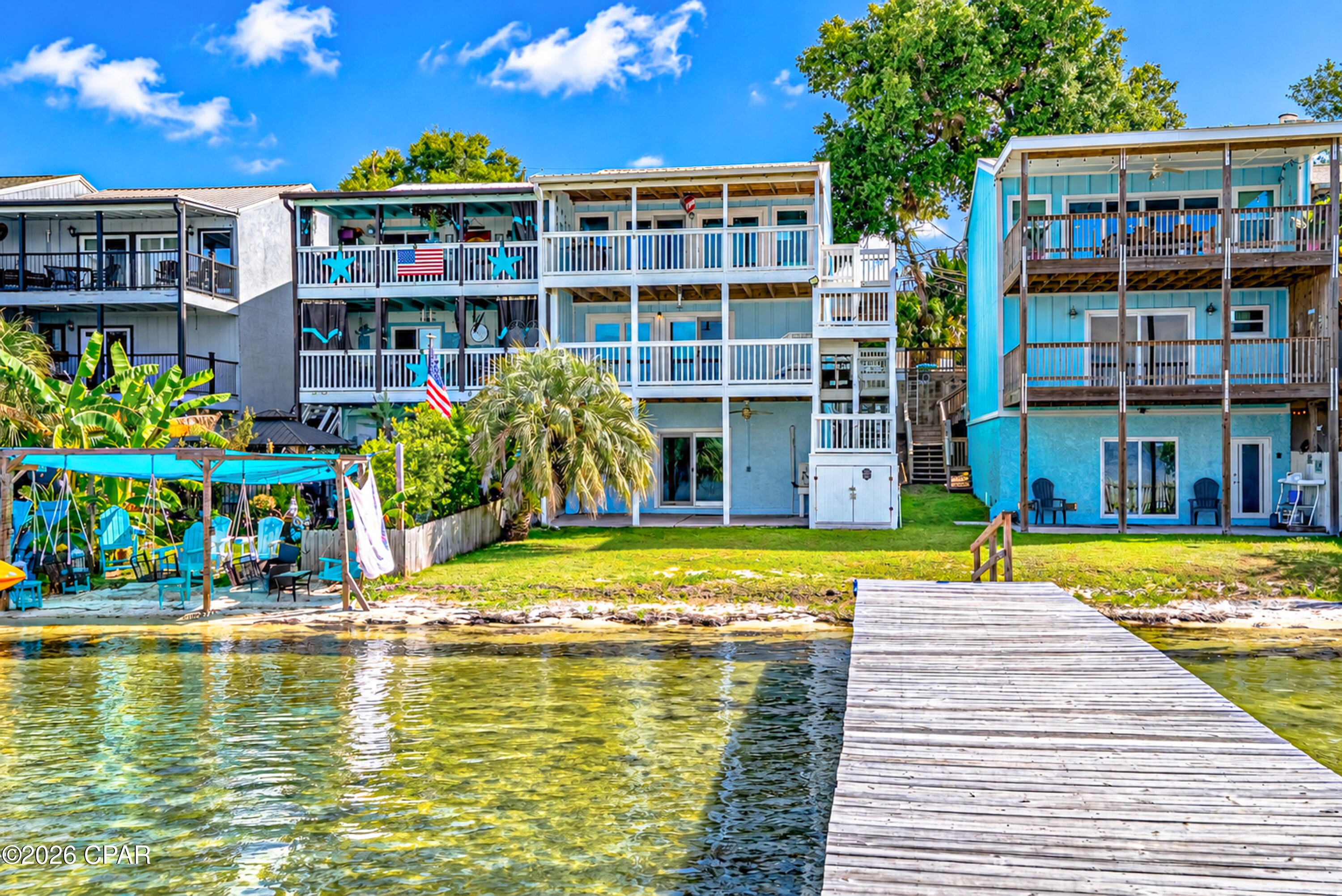 Incredible views from this Bay Front 3 bedroom 2.5 bath Townhome with 1 bedroom 1 bath mother-n-law apartment on ground floor. Boat dock is almost directly in front of this unit, each owner in this group of townhomes has 1/11th deeded ownership, No HOA fees. The main living unit has a really great split level floor plan. Drive up parking for 2 cars. Enter the unit on living room level featuring upon entry kitchen, 1/2 bath and  large living room with dining nook. Covered balcony access overlooking the dock and the bay. Head downstairs to your primary bedroom with amazing views of the bay with covered balcony. Just down the hallway you'll find 2 guest bedrooms, a shared full bath, and full size laundry. Head down the exterior stairs to access your full mother-n-law apartment with 1 bedroom, 1 bath, w/ laundry. Both upstairs and mother-n-law have share utilities. The mother-n-law unit features a galley style kitchen and again amazing views of the bay from living room w/ covered porch area off the living space. This townhome is located in Parker, you are a short drive to Tyndall AFB, downtown Panama City, Callaway, and by boat, marina services are a quick boat ride in either direction. Easy boating access to the intercostal, Shell Island, or St Andrew's Pass for gulf access. Pier 99 Marina and Watson Marina are both a short boat ride for fuel, bait, and supplies. The possibilities are here for rental income, Live upstairs and rent downstairs or vice versa. Owner had Peaden install new HVAC in 2023 and has a service contract with Peaden.