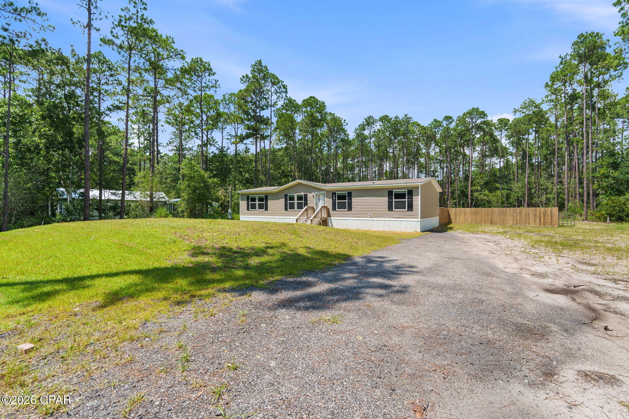This 2025 Marvel double-wide manufactured home sits on approximately 0.88 acres with nearly 150 feet of road frontage along a paved road. Offering 4 bedrooms, 2 bathrooms and a split-bedroom floor plan, the home combines modern finishes with generous indoor and outdoor living space. Luxury vinyl plank flooring runs throughout, complemented by quartz countertops, blinds and upgraded closet systems. The kitchen features Frigidaire appliances, ample cabinetry and a large center island with additional prep space, storage and seating. In addition to the main living room, a separate den provides flexible space for a home office, media room or additional living area. The primary suite includes a walk-in closet and private bath featuring a tiled walk-in shower with bench seating and glass enclosure. The guest bathroom also features a tiled shower with bench seating and glass doors. A dedicated utility closet adds convenient storage and functionality. Outside, enjoy a privacy-fenced backyard area and backyard patio with room to relax or entertain. With nearly an acre of land, substantial paved road frontage and thoughtfully selected finishes throughout, this property offers a great combination of space, functionality and modern design. If important, buyer to verify all measurements and property details. Call a REATLOR® today for a private tour.