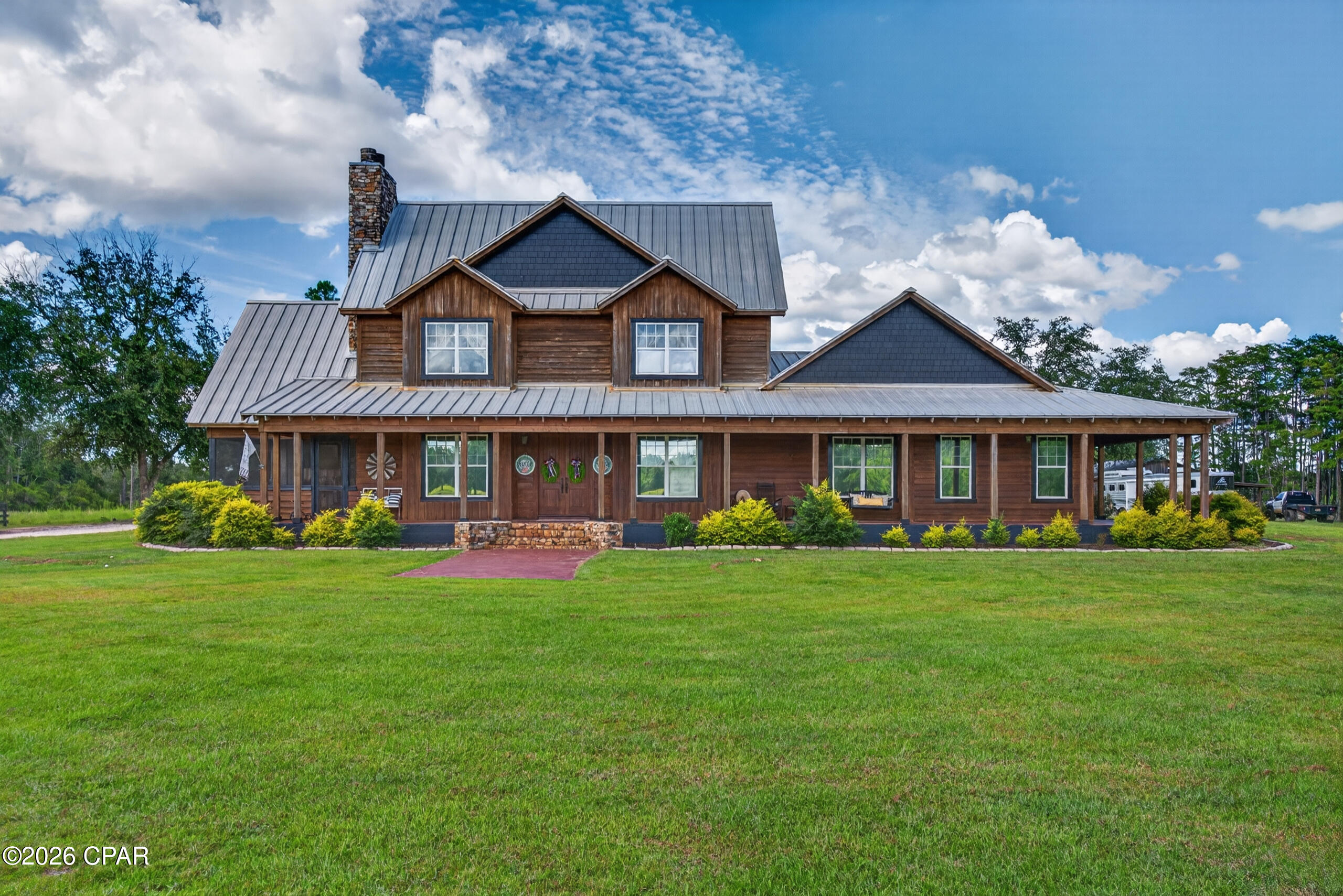 CURRENTLY UNDER CONTRACT, SELLER WILL CONSIDER BACKUP OFFERS. Welcome to your private luxury retreat tucked away on 12 beautiful acres, where rustic charm meets modern comfort. This stunning 5-bedroom, 2.5-bath cabin-style home offers a rare combination of craftsmanship, space, privacy, and exceptional outdoor living. From the moment you arrive, the inviting gravel driveway leads you to a property designed for those who appreciate the beauty of country living without sacrificing quality and convenience. The home features a warm and inviting rustic design with a gorgeous wood exterior, wrap-around porch, and timeless cabin-inspired character. Inside, you will find spacious living areas filled with charm, including gas fireplaces that create the perfect atmosphere for cozy evenings. The thoughtfully designed floor plan offers 5 bedrooms along with a dedicated craft room/flex space, providing plenty of room for hobbies, a home office, guest accommodations, or additional living space. Step outside and experience an entertainer's dream. The outdoor living area is truly one-of-a-kind, featuring a custom outdoor kitchen, gathering spaces perfect for hosting family and friends, and a relaxing stock tank pool overlooking the peaceful surroundings. Whether you are enjoying morning coffee on the porch, entertaining under the stars, or unwinding after a long day, this property was designed to embrace the outdoor lifestyle.
The acreage offers endless possibilities with a peaceful aerated pond and multiple impressive outbuildings. The enclosed pole barn measures approximately 76x24 and is equipped with water, electricity, and a concrete floor, making it ideal for a workshop, storage, equipment, hobbies, or a variety of uses. An additional open pole barn measuring approximately 96x44 provides even more covered space for vehicles, equipment, recreational toys, or future projects. Additional features include a Generac whole-home generator for peace of mind, a spacious carport, and a beautiful sleeping porch that adds even more charm and functionality to this already exceptional property. This is more than just a home, it is a private escape offering the perfect blend of rustic elegance, modern amenities, and outdoor adventure. Whether you are searching for a full-time residence, family retreat, or a place to create lasting memories, this rare property delivers a lifestyle that is becoming increasingly hard to find.