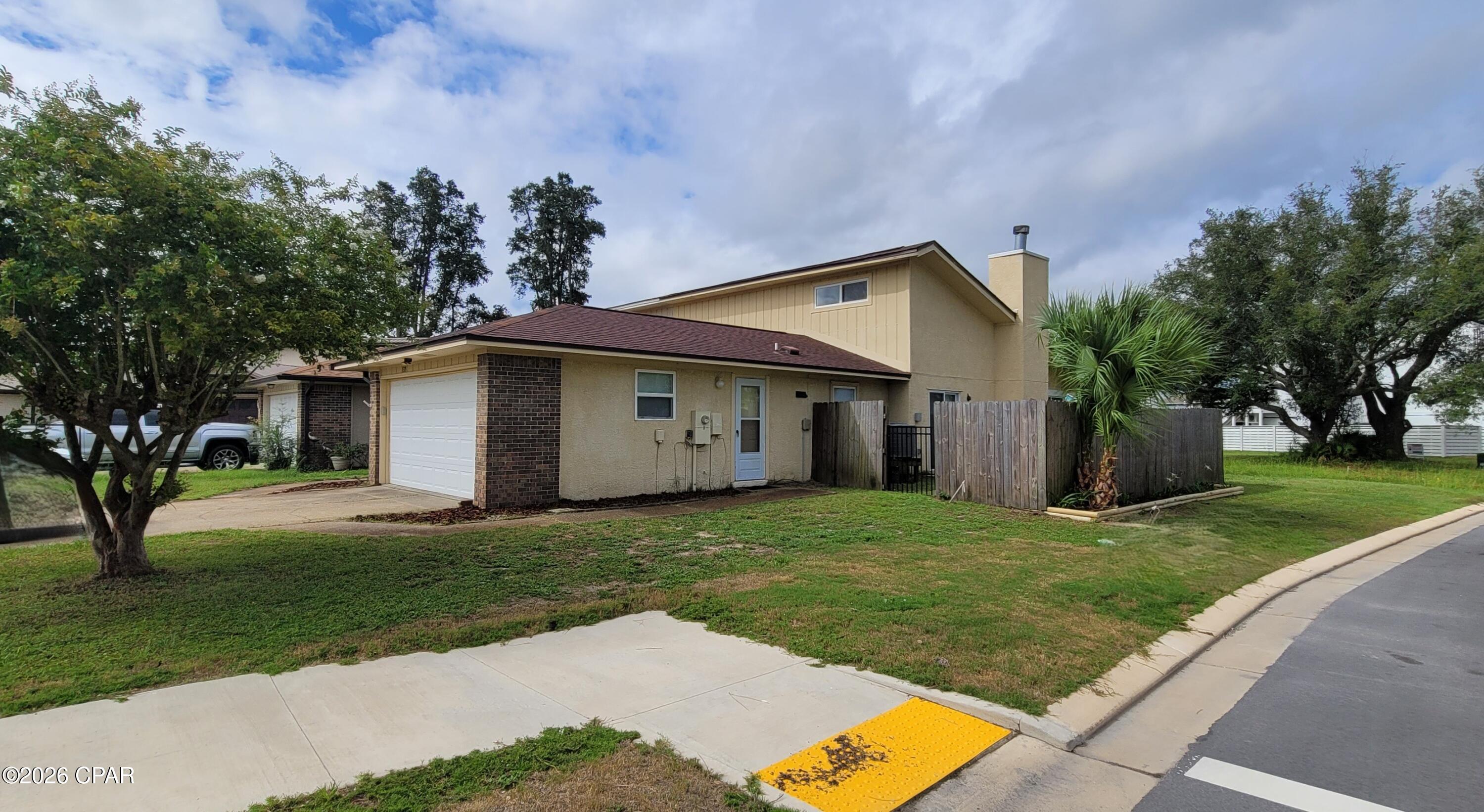 End Unit Rowhome with large corner lot. Cute 2-bedroom split bedroom plan, 2 bath and 2 car garage. This home features an open living room/dining area with vaulted ceilings, wood burning fireplace, wood plank marble tile throughout, kitchen has stainless appliances, granite countertops, pantry closet, W/D hookups in the garage, master bedroom suite, master bath with dressing area and walk-in closet. Privacy fenced side yard with open patio off the dining area, back screened in patio with tile floor and is off the living area with view of the bay and an additional large open patio. Shed for tenant use. The home is ALL ELECTRIC!